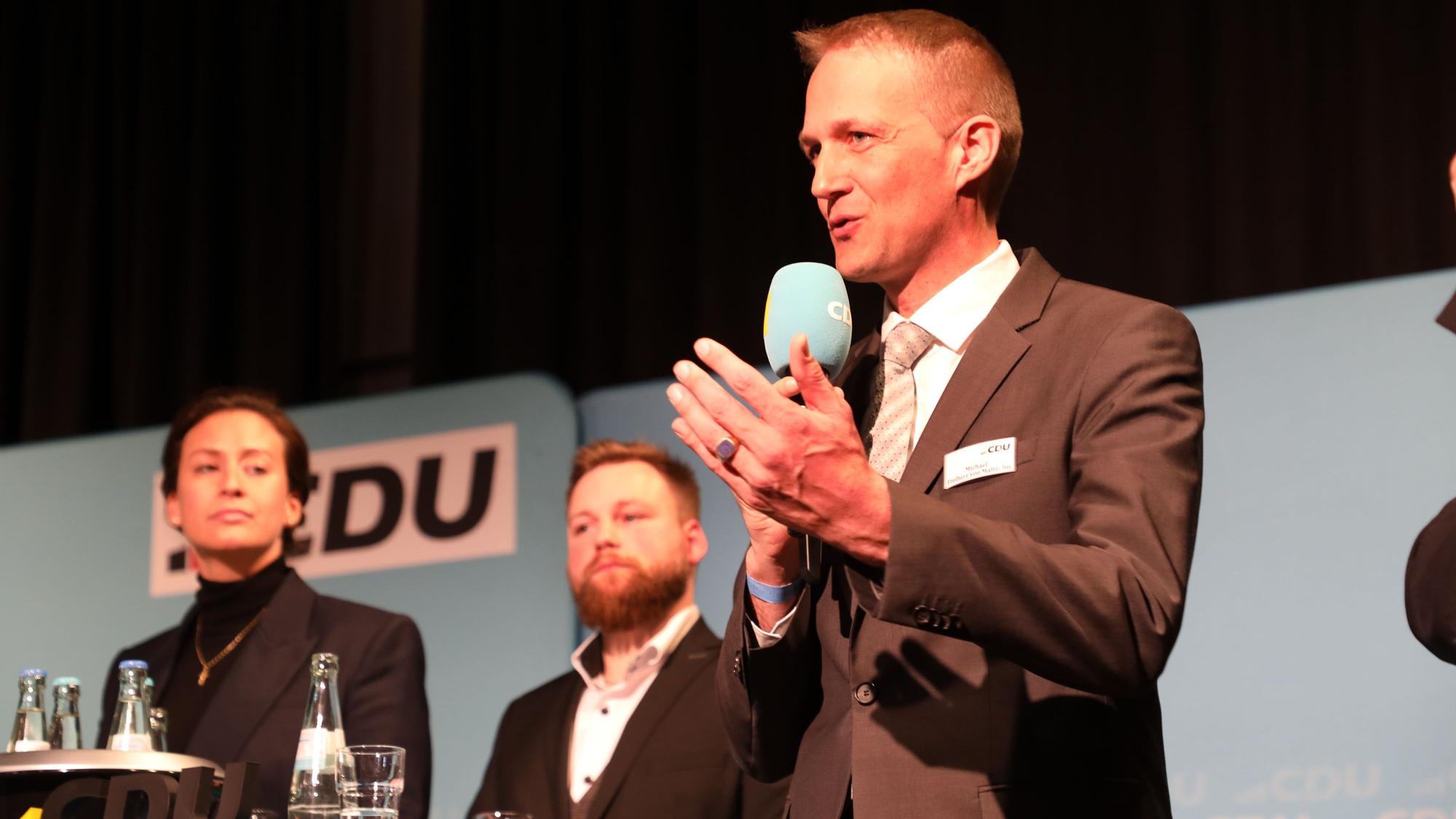 Caroline Bosbach (34) aus Bergisch Gladbach, Fabian Felder aus Bergisch Gladbach und Michael Freiherr von Maltzahn aus Burscheid stehen auf einer Bühne vor einer CDU-Wand.