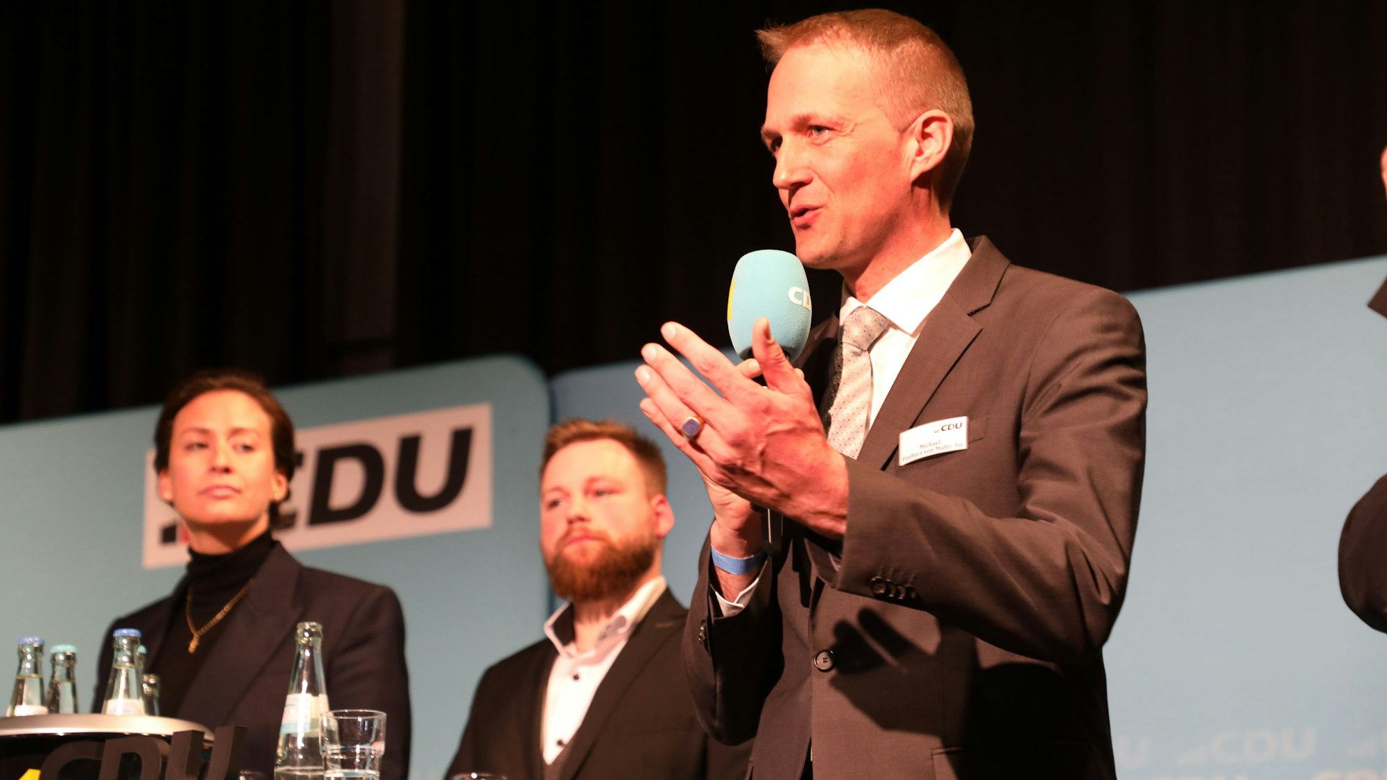 Caroline Bosbach (34) aus Bergisch Gladbach, Fabian Felder aus Bergisch Gladbach und Michael Freiherr von Maltzahn aus Burscheid stehen auf einer Bühne vor einer CDU-Wand.