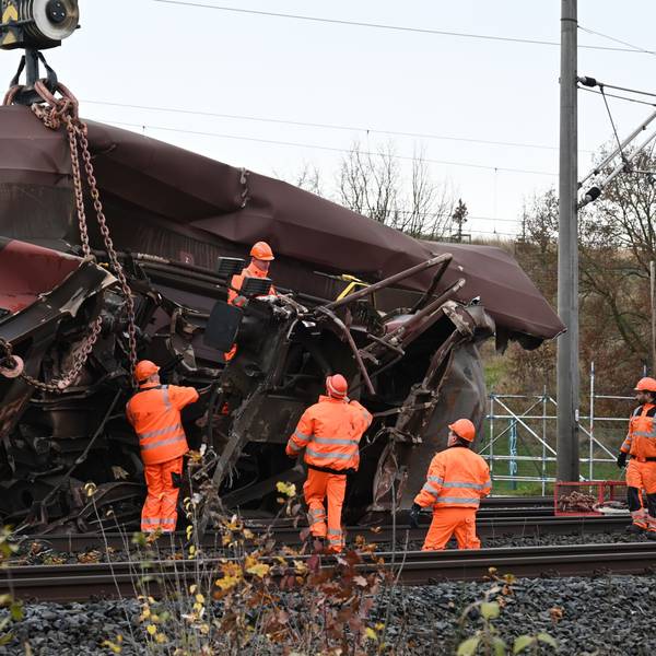 Das Bild zeigt mehrere Arbeiter an einem verunglückten Waggon.