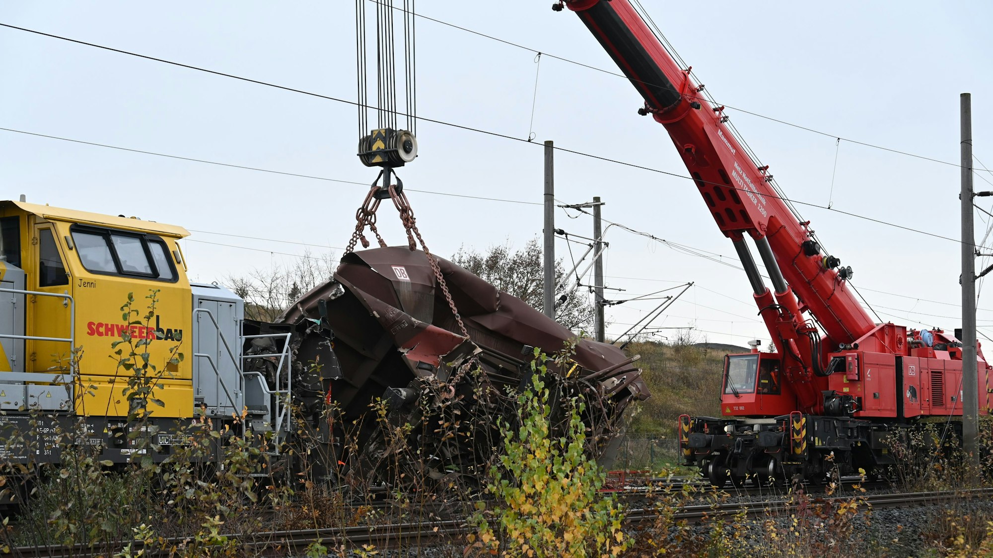 Kerpen: Ein zerstörter Wagen wird von einem Kran von den Gleisen gehoben.