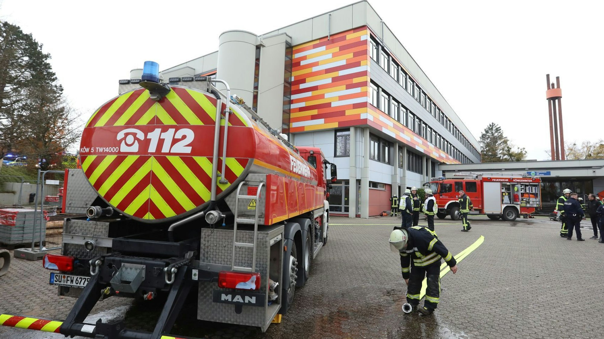 Ein Tanklöschwagen und mehrere Feuerwehrleute vor dem Schulzentrum Oberpleis.