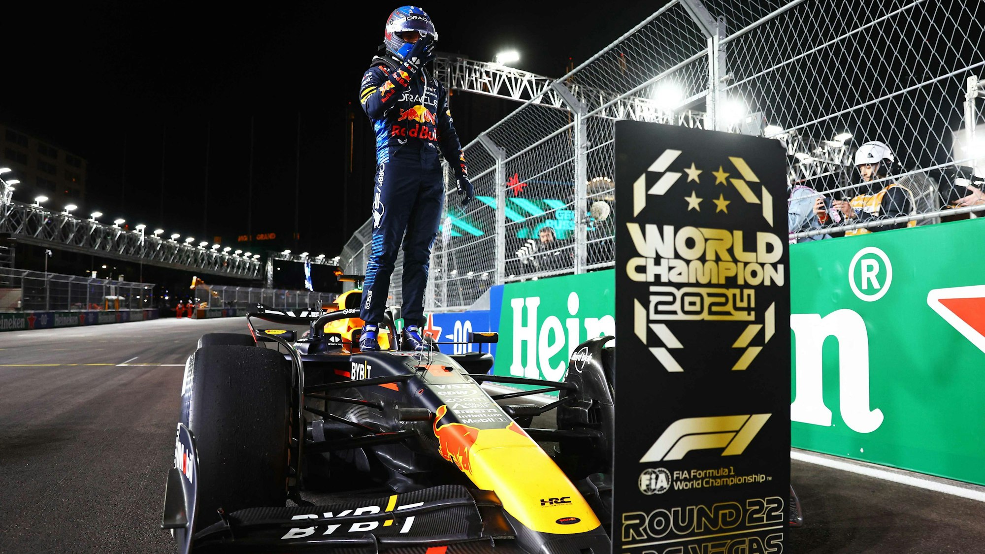 Max Verstappen steht auf seinem Wagen und feiert seinen vierten Titel.