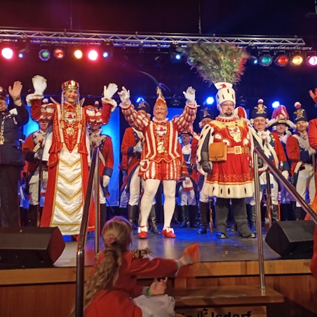 Das Foto zeigt das proklamierte Dreigestirn auf der Bühne.