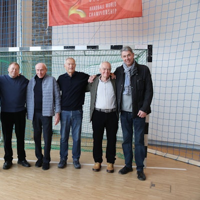 Ehemalige VfL-Handballprofis und -meister stehen für ein Gruppenbild in Handballausstellung zusammen.
