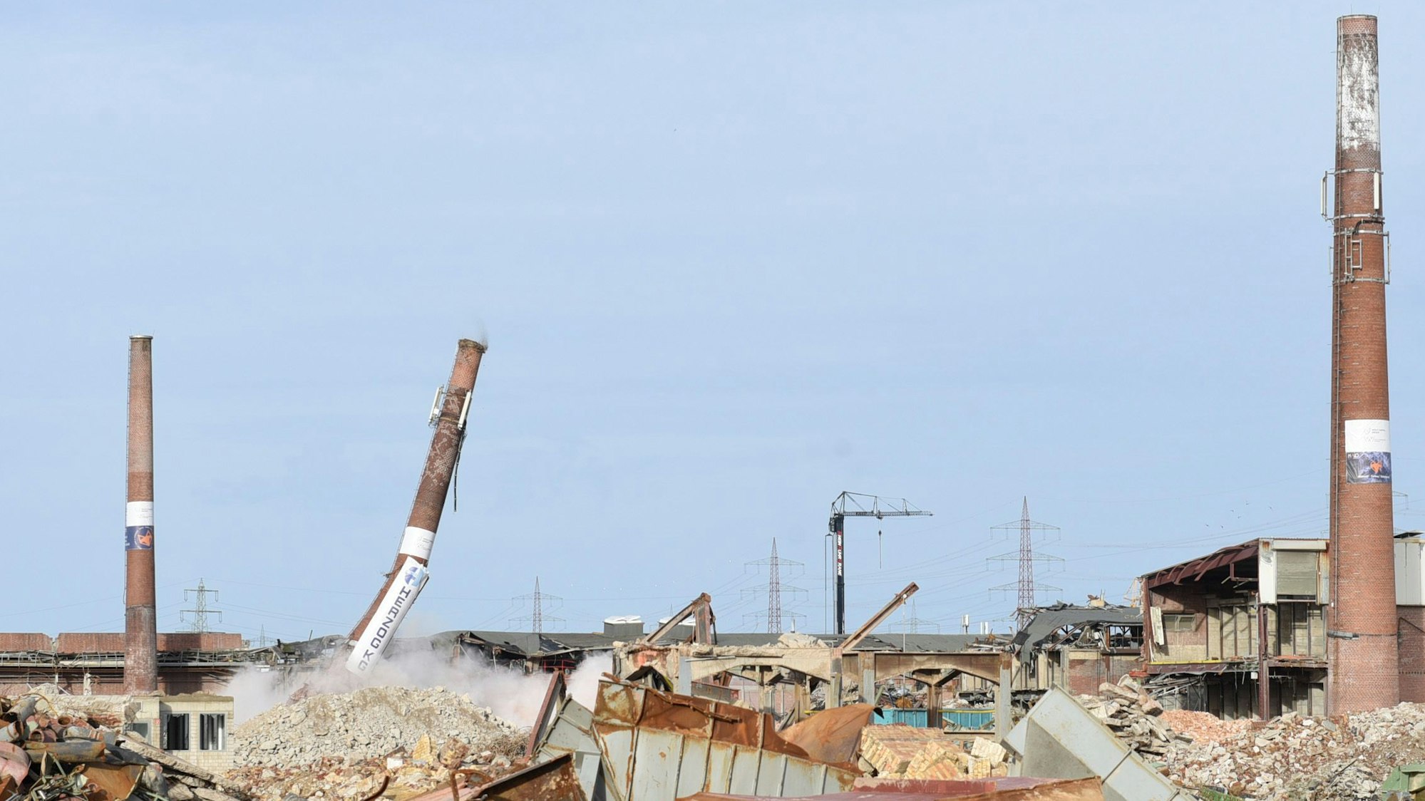 Das Bild zeigt ein Fabrikgelände in Frechen. Einer der Schornsteine kippt gerade um.