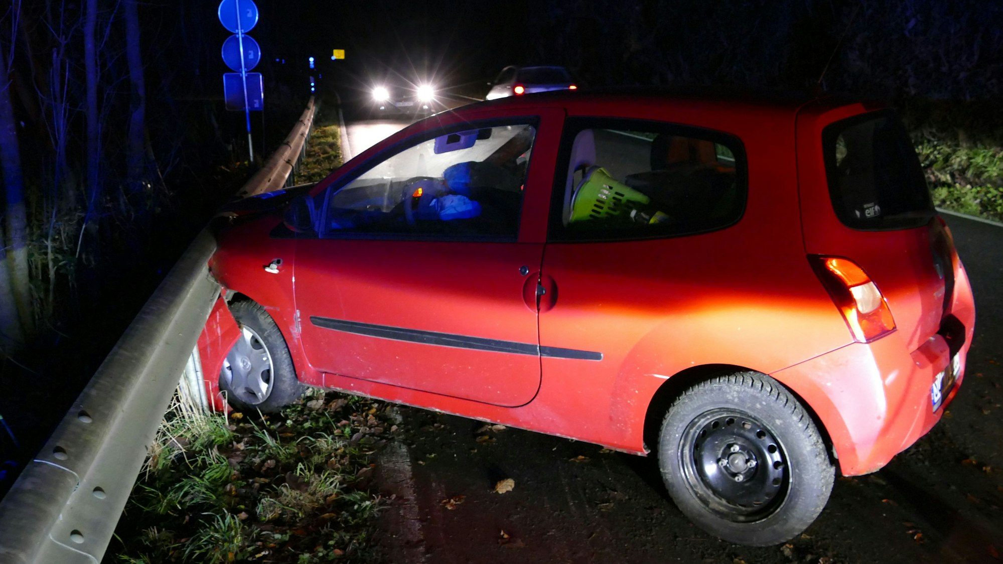 Ein Auto steht an einer Schutzplanke, die Front ist eingedrückt.