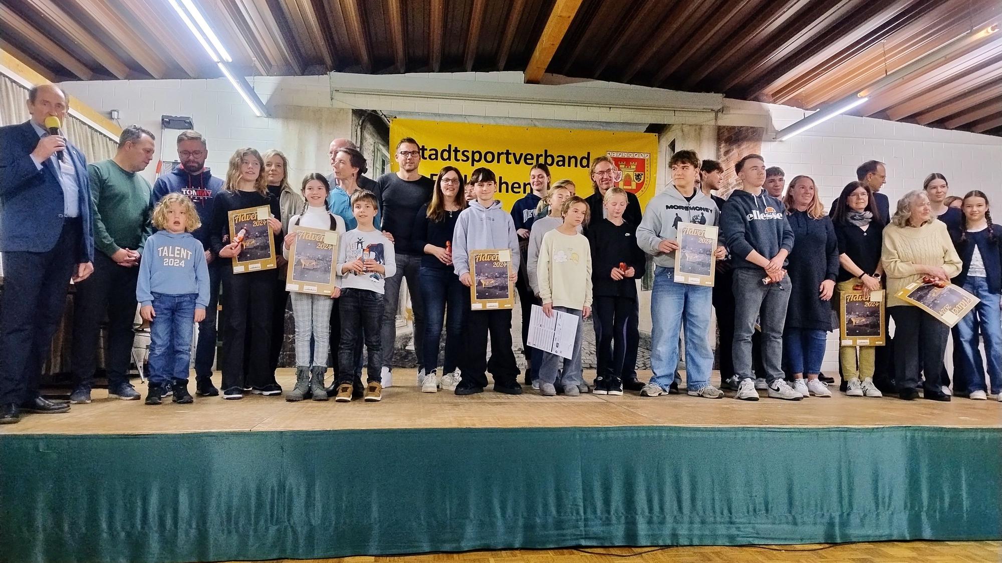 Einige der insgesamt 218 Sportabzeichenabsolventen stehen mit ihren Urkunden auf der Bühne des Schützenhauses in Kuchenheim.