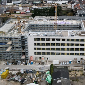 Ein Luftbild zeigt die Baustelle, aus der zwei Kräne herausragen.