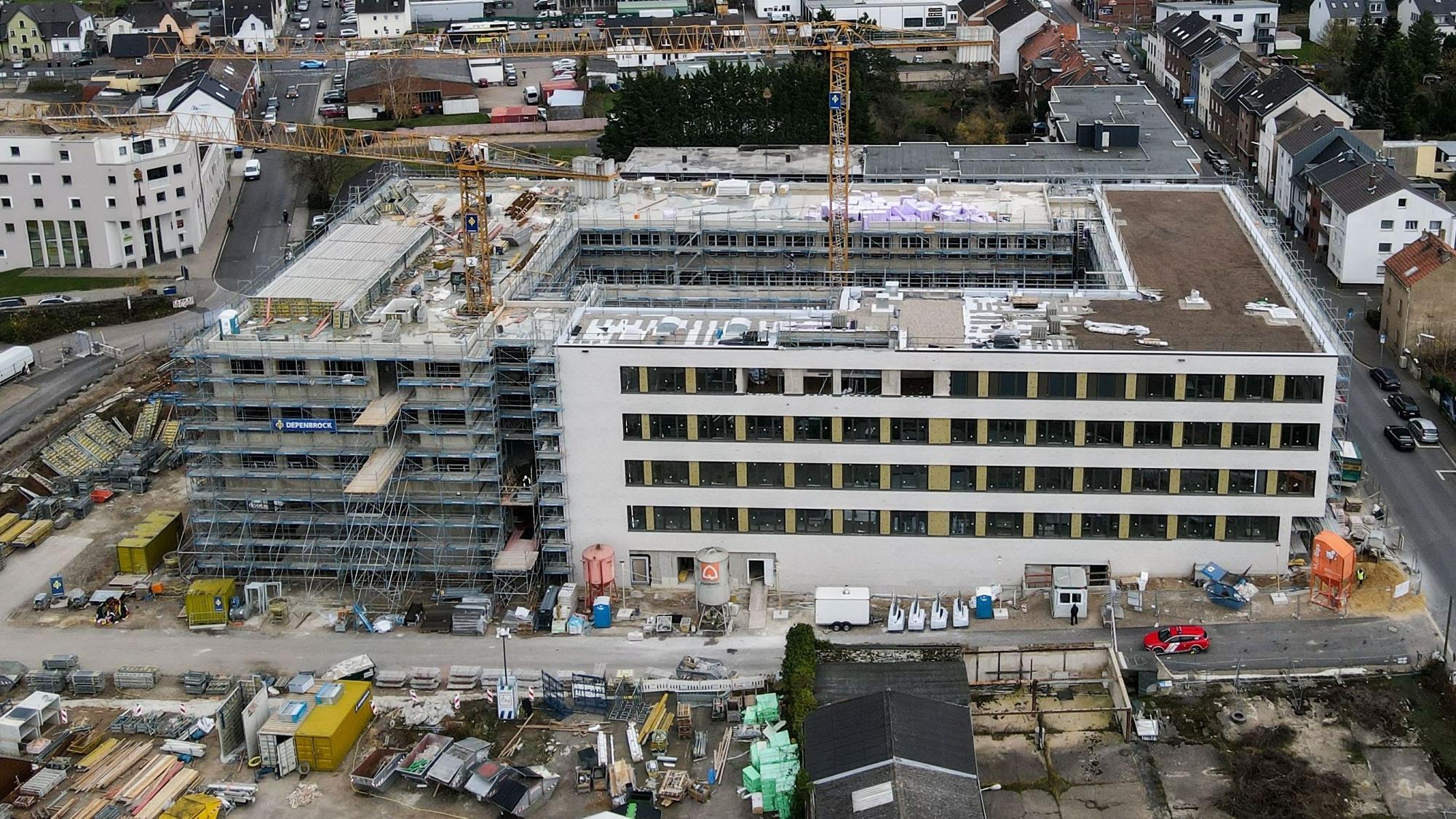 Ein Luftbild zeigt die Baustelle, aus der zwei Kräne herausragen.