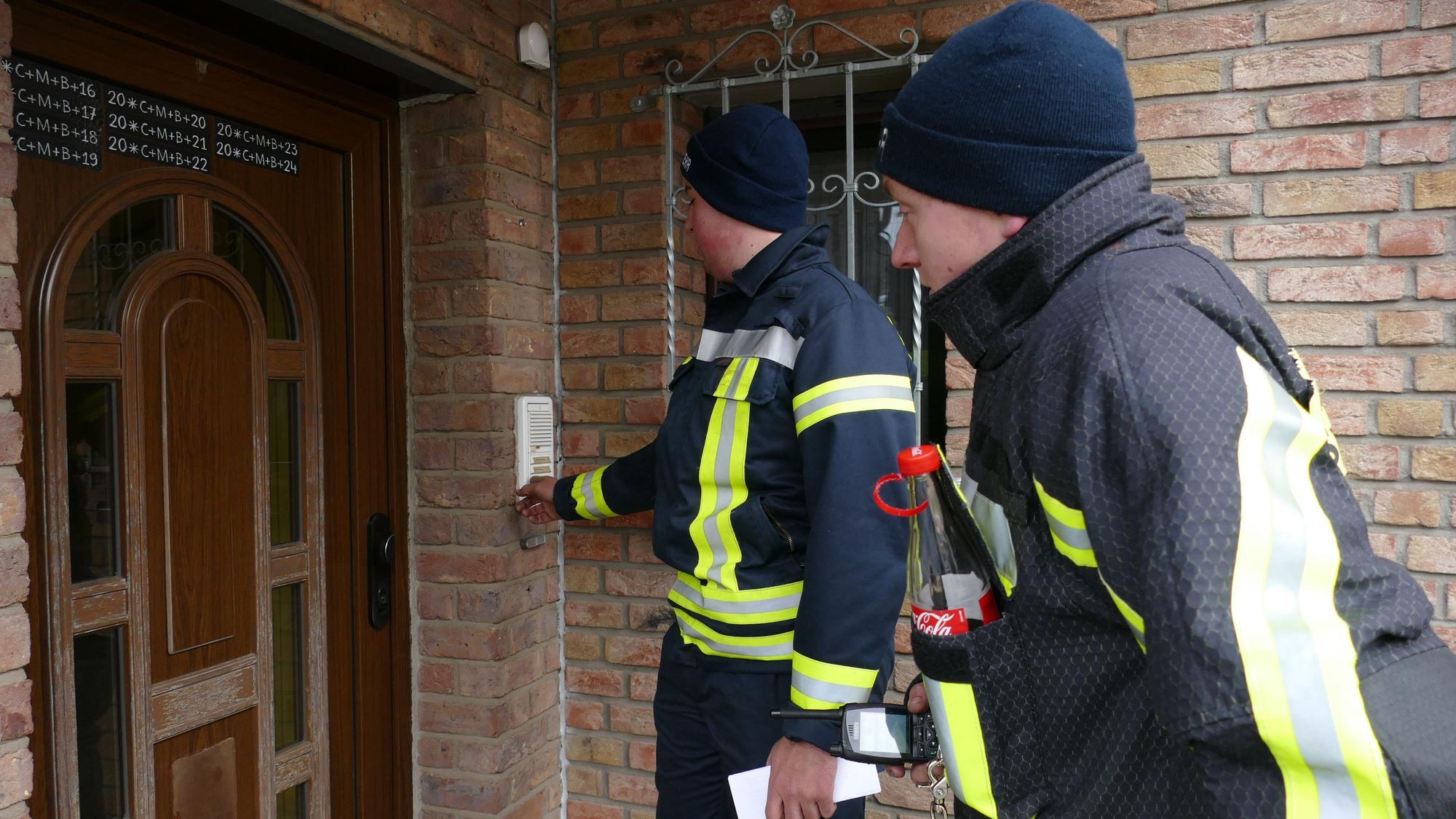 Die Feuerwehrleute klingeln an den Haustüren und sprechen mit den Bewohnern, um zu überprüfen, ob sie Hilfe brauchen.