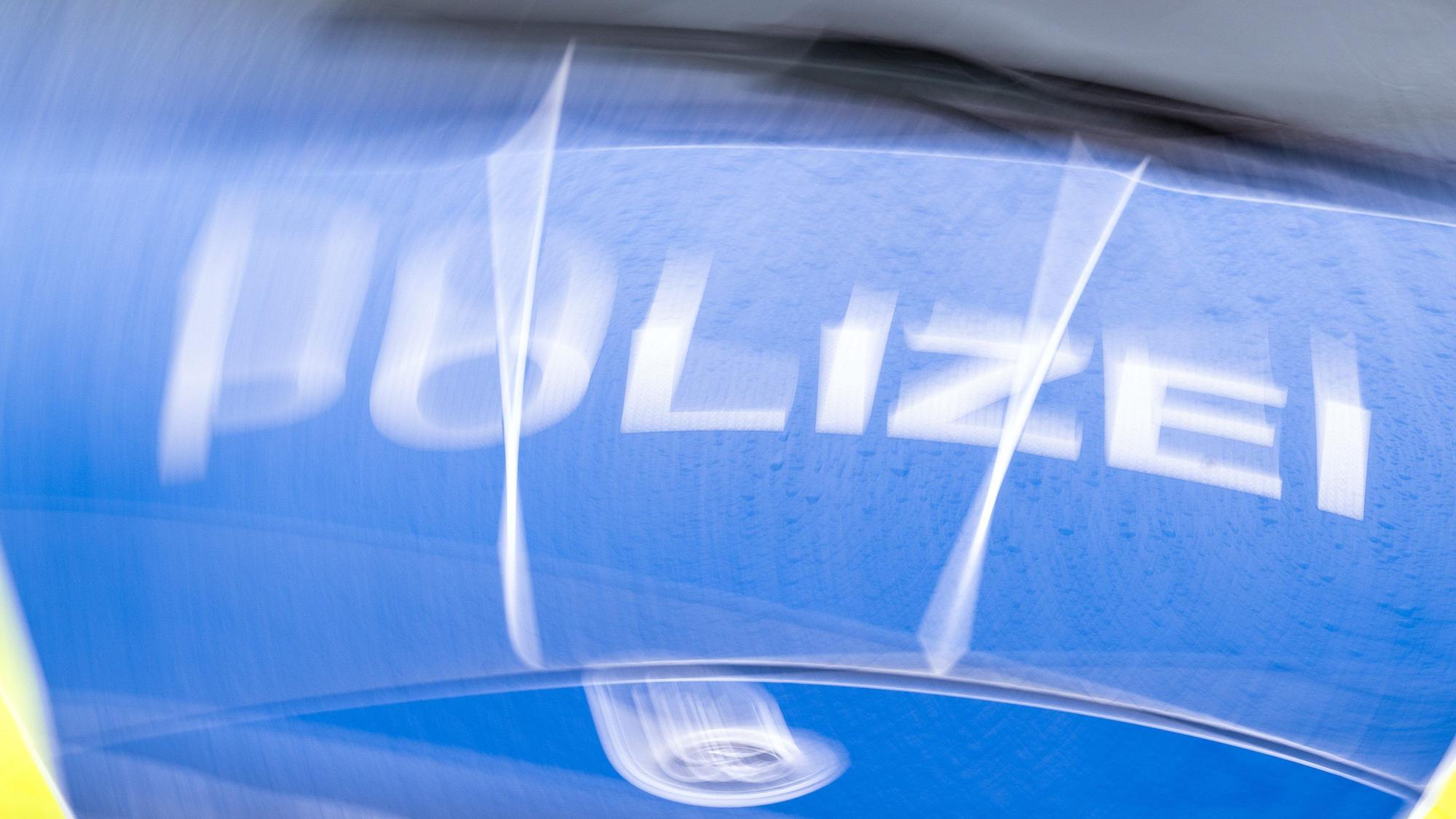 Auf der Kühlerhaube eines Autos steht der Schriftzug „Polizei“.