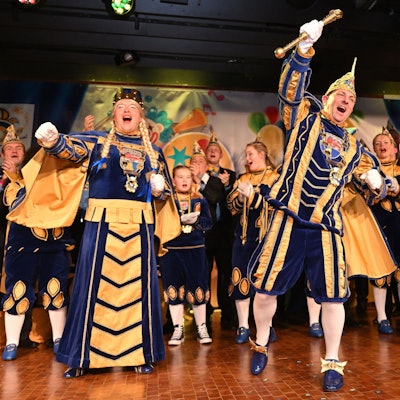 Das Obverather Dreigestirn steht auf der Bühne der Cyriax-Aula bei der Kostümsitzung mit Proklamation.