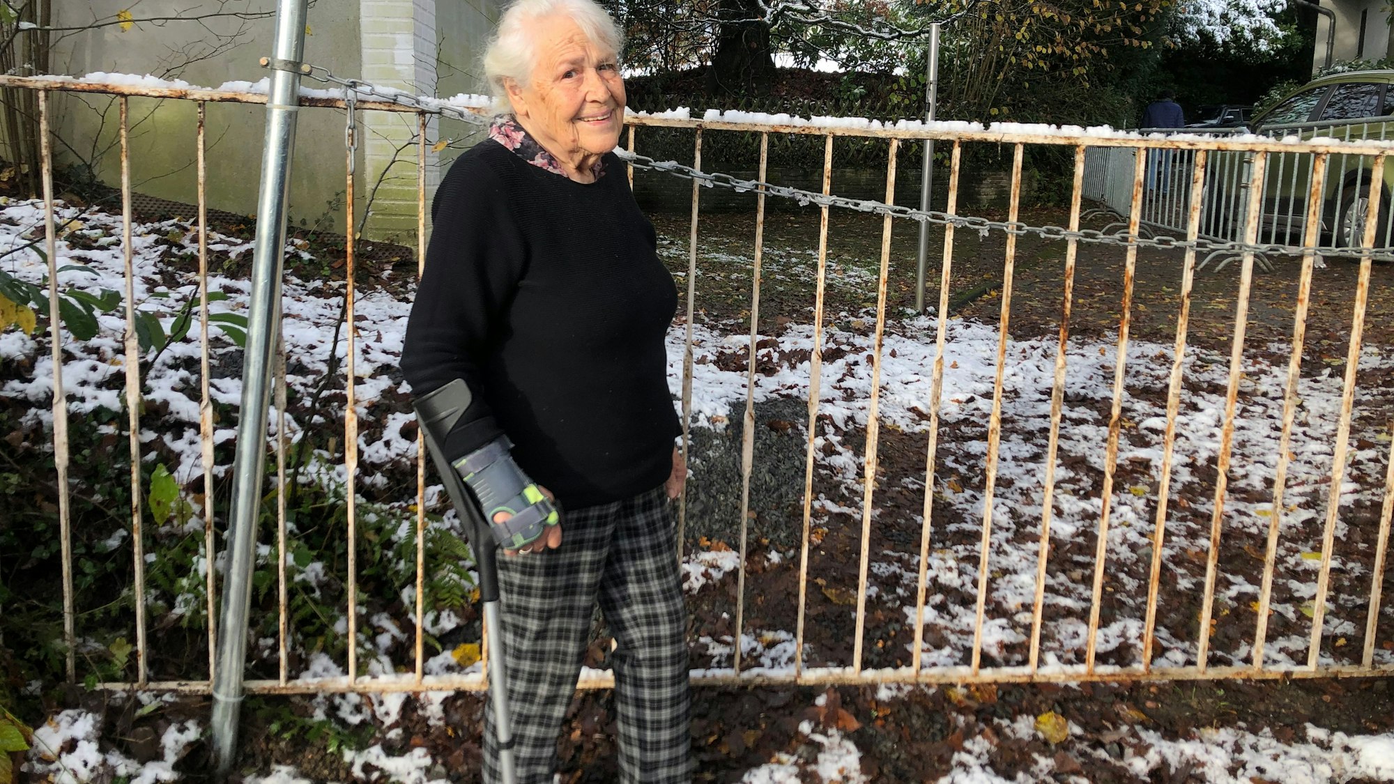 Irmintraut Fuchs an dem Zaun, den ihr Nachbar aufgebaut hat und der den Zugang zu ihrem Grundstück versperrt.