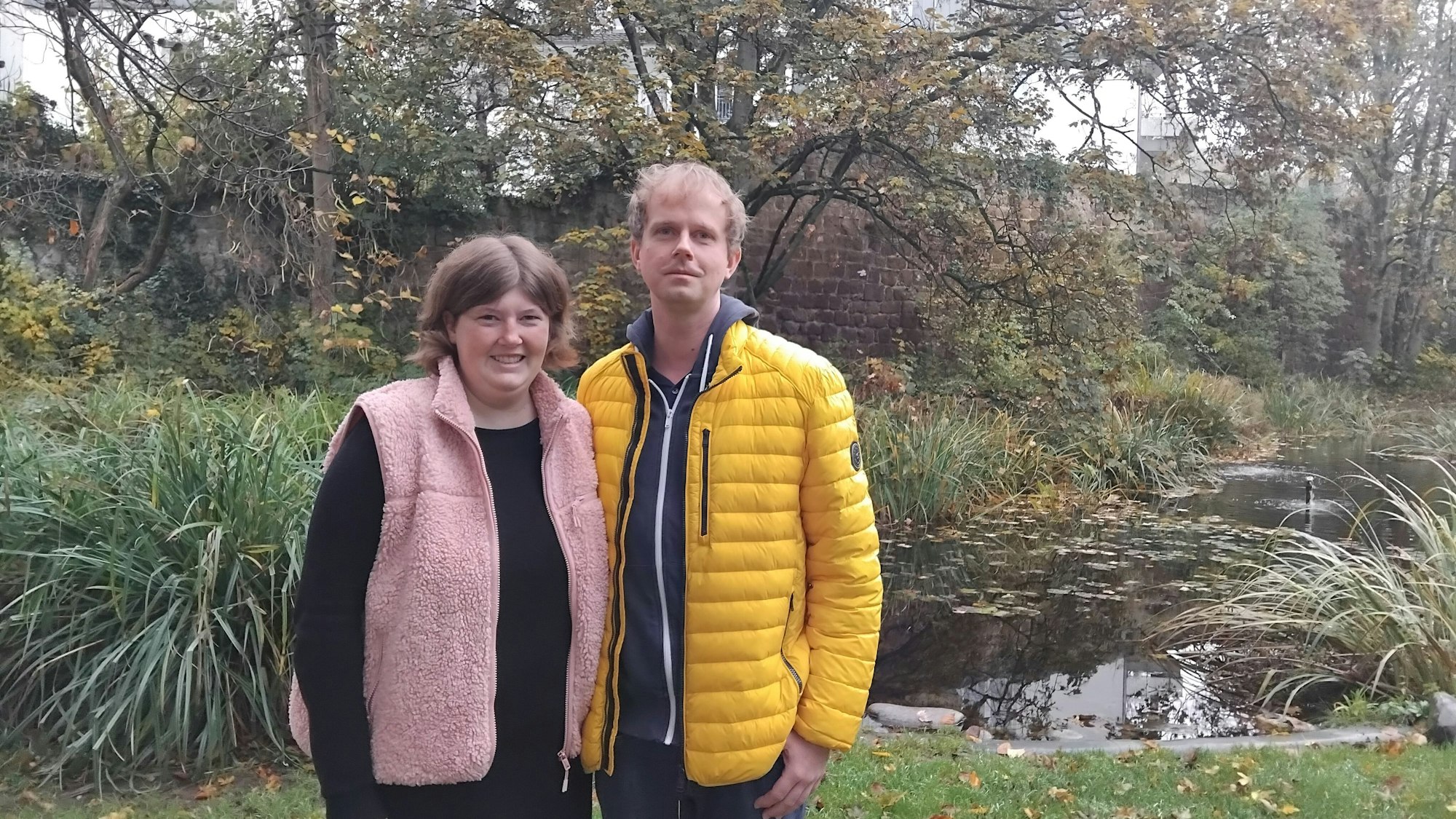 Eine Frau und ein Mann stehen vor einem Teich