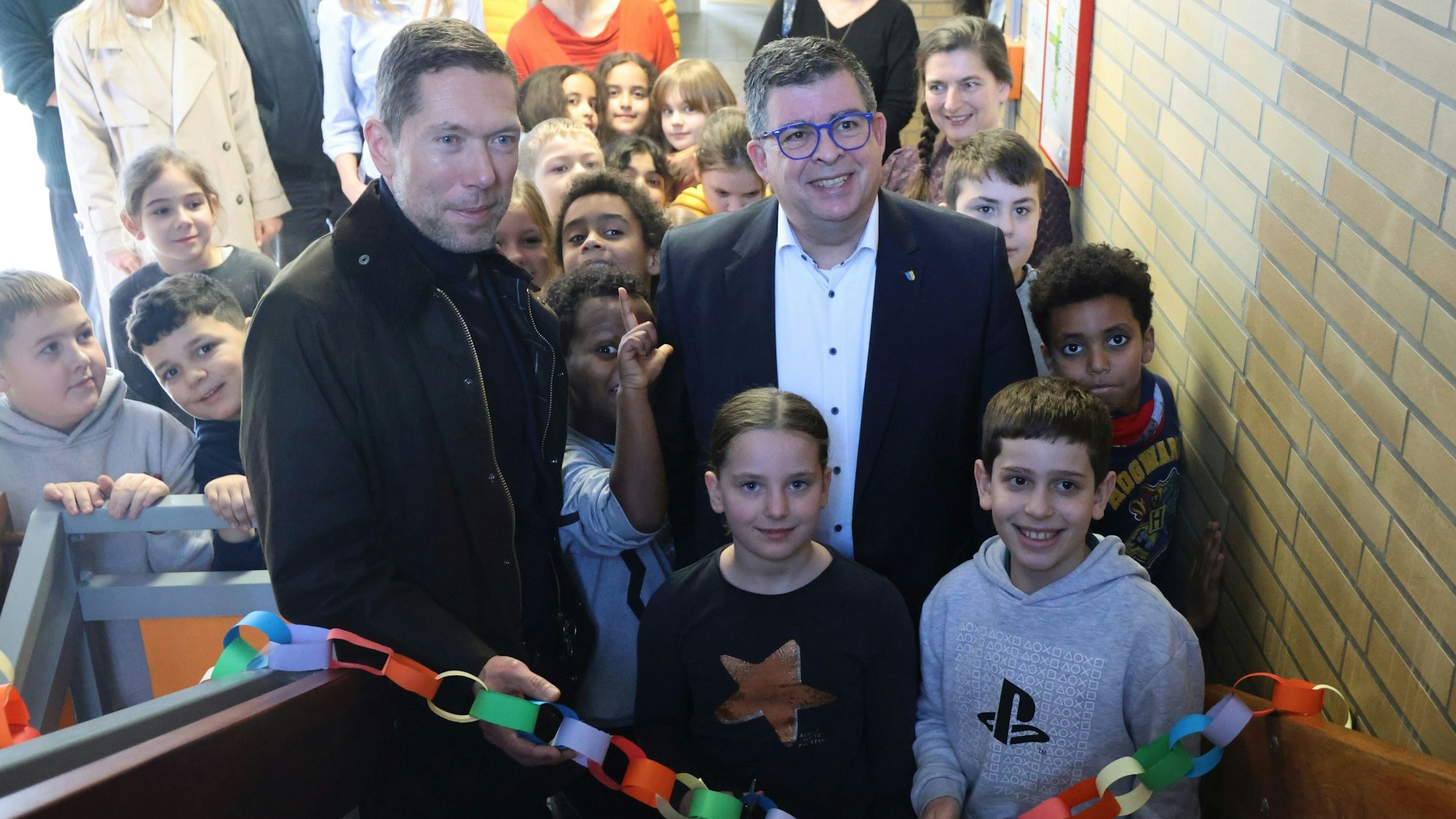 Romy und Tarik zerschnitten mit Frank Helmenstein (r.) und Schuldezernent Raoul Halding-Hoppenheit die Regenbogenkette.