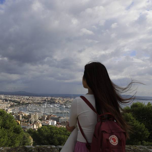 Spanien, Palma: Ein Mädchen schaut an einem bewölkten Tag vom Bellver-Hügel in Palma auf Mallorca aus auf die Stadt Palma.