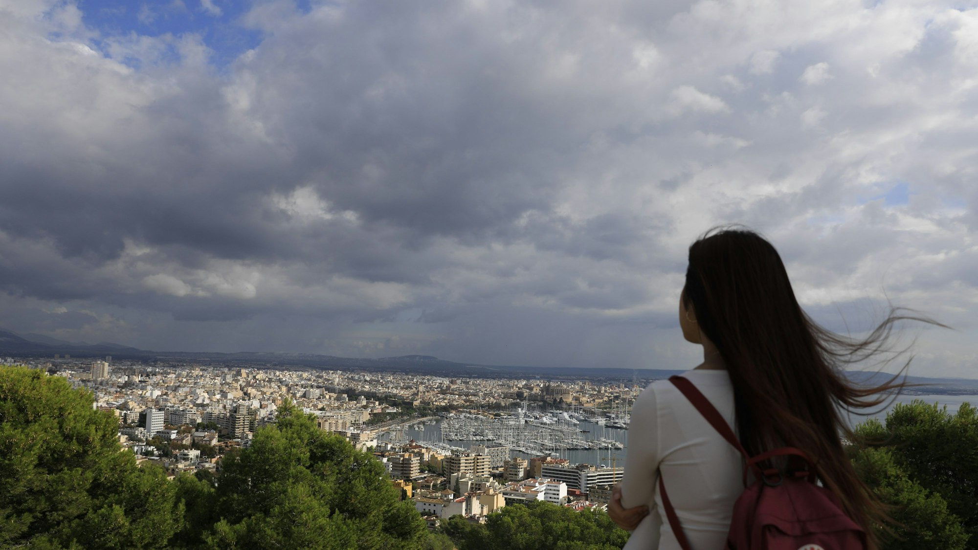 Spanien, Palma: Ein Mädchen schaut an einem bewölkten Tag vom Bellver-Hügel in Palma auf Mallorca aus auf die Stadt Palma.