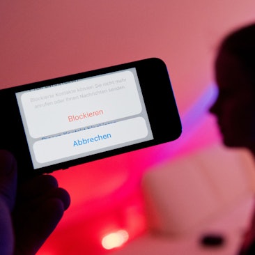 Ein junges Mädchen zeigt am 04.02.2017 das Display eines Smartphones mit einem Button „Blockieren“ beim Messenger WhatsApp (gestellte Szene).