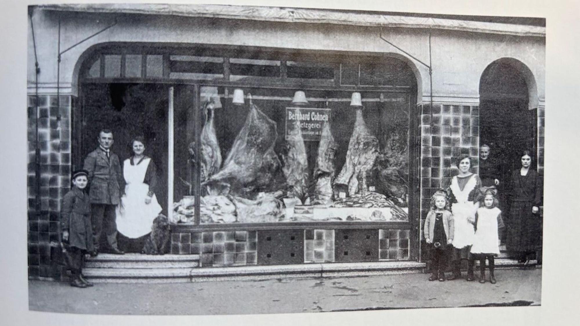 Auf dem Bild ist eine historische Aufnahme einer Metzgerei und der Inhaberfamilie zu sehen.