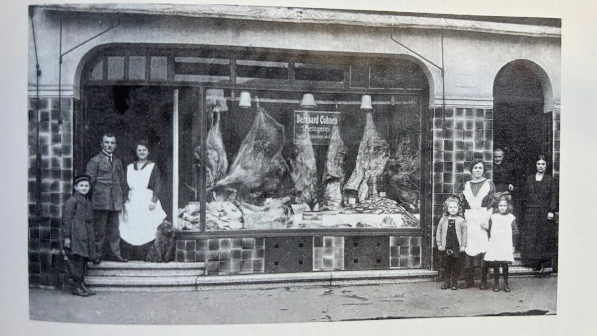 Auf dem Bild ist eine historische Aufnahme einer Metzgerei und der Inhaberfamilie zu sehen.