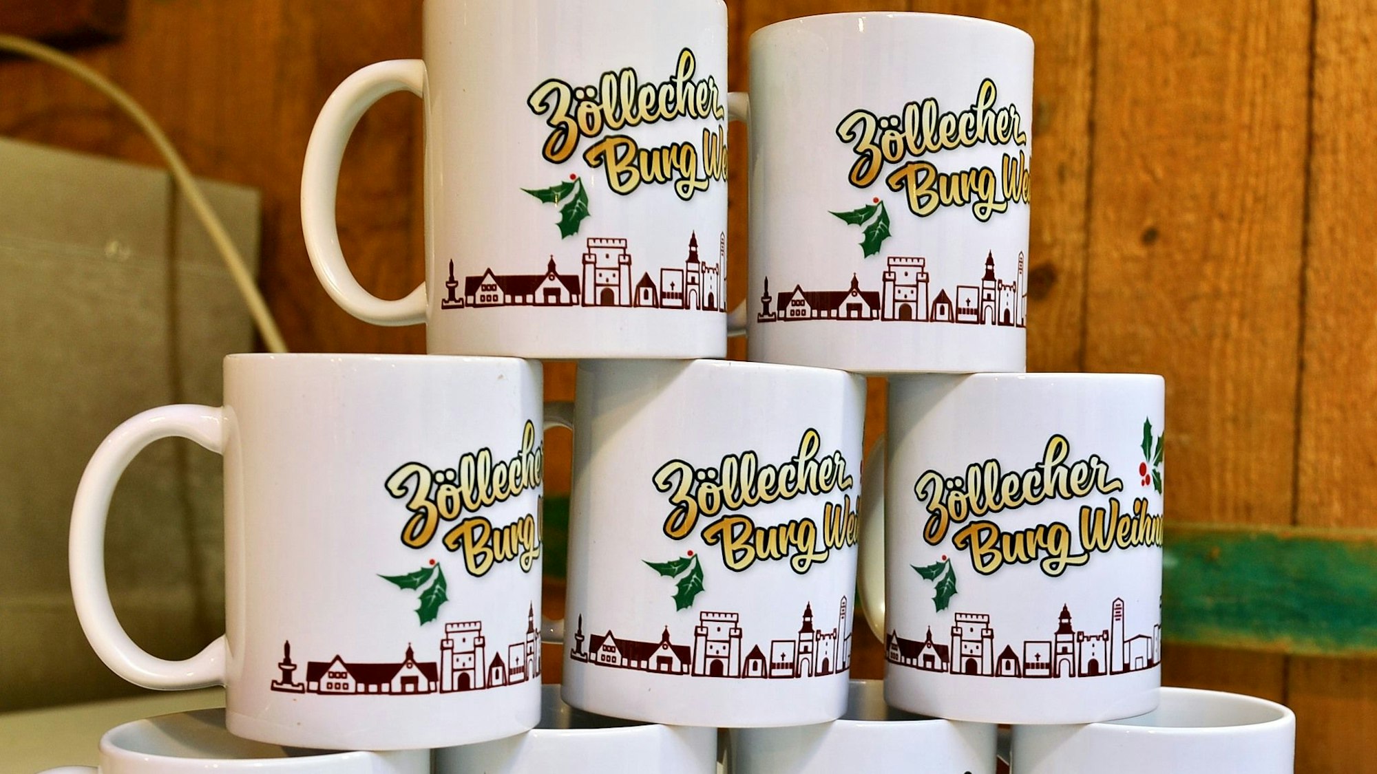 Tassen mit der Aufschrift „Zöllecher Burg Weihnacht“ sind aufeinander gestapelt.