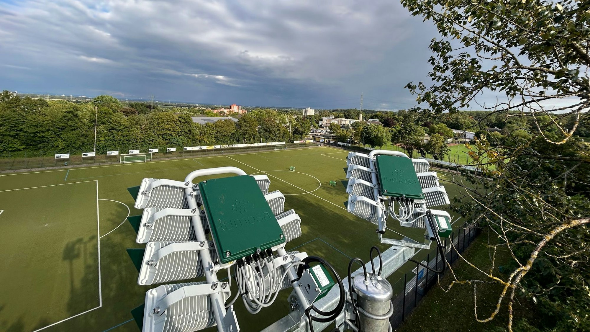 Auf dem Bild ist eine Luftaufnahme einer Flutlichtanlage und ein Sportplatz zu sehen.