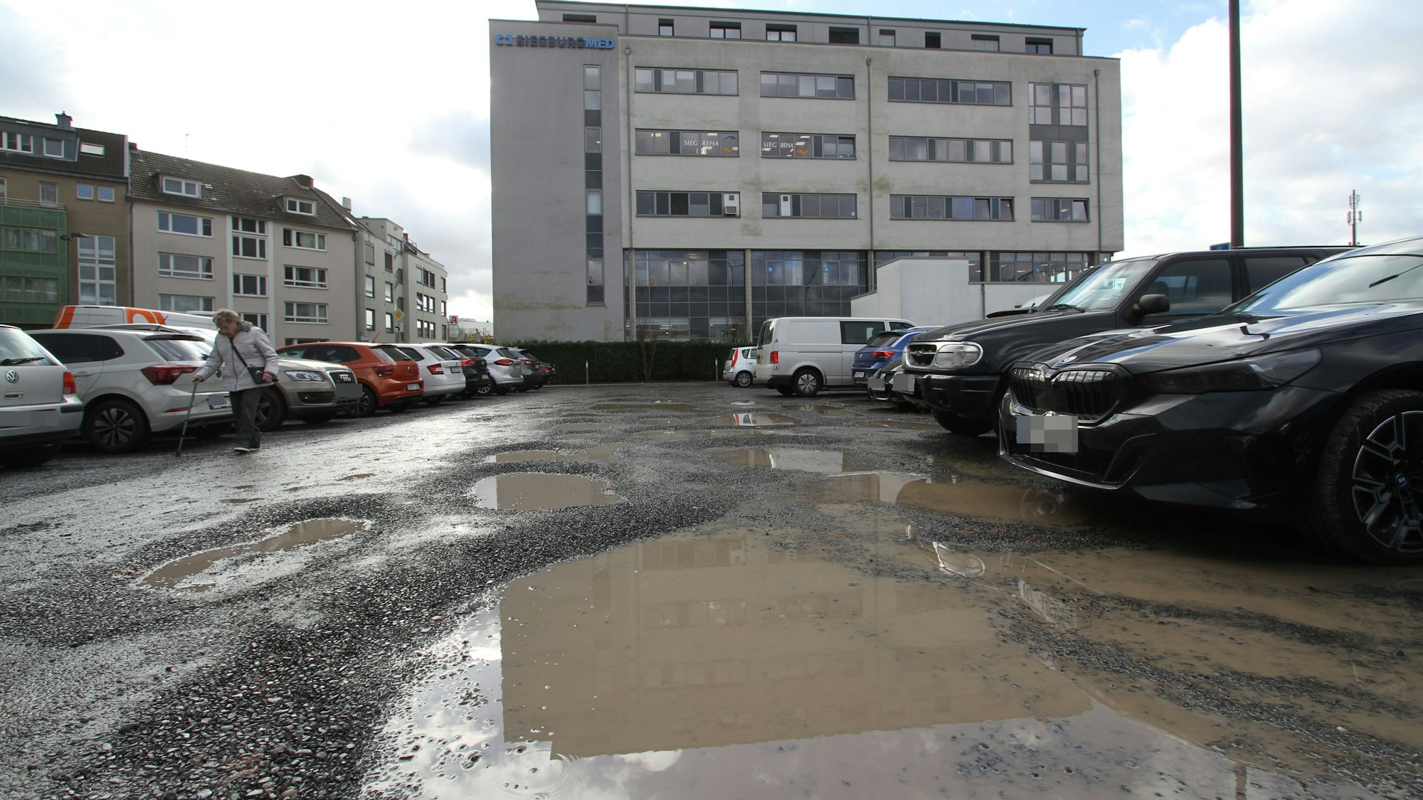 Pfützen auf dem Parkplatz am Siegburgmed