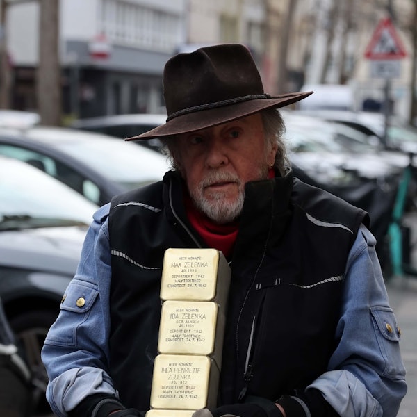 Gunter Demnig hält zwei Stolpersteine in den Händen.
