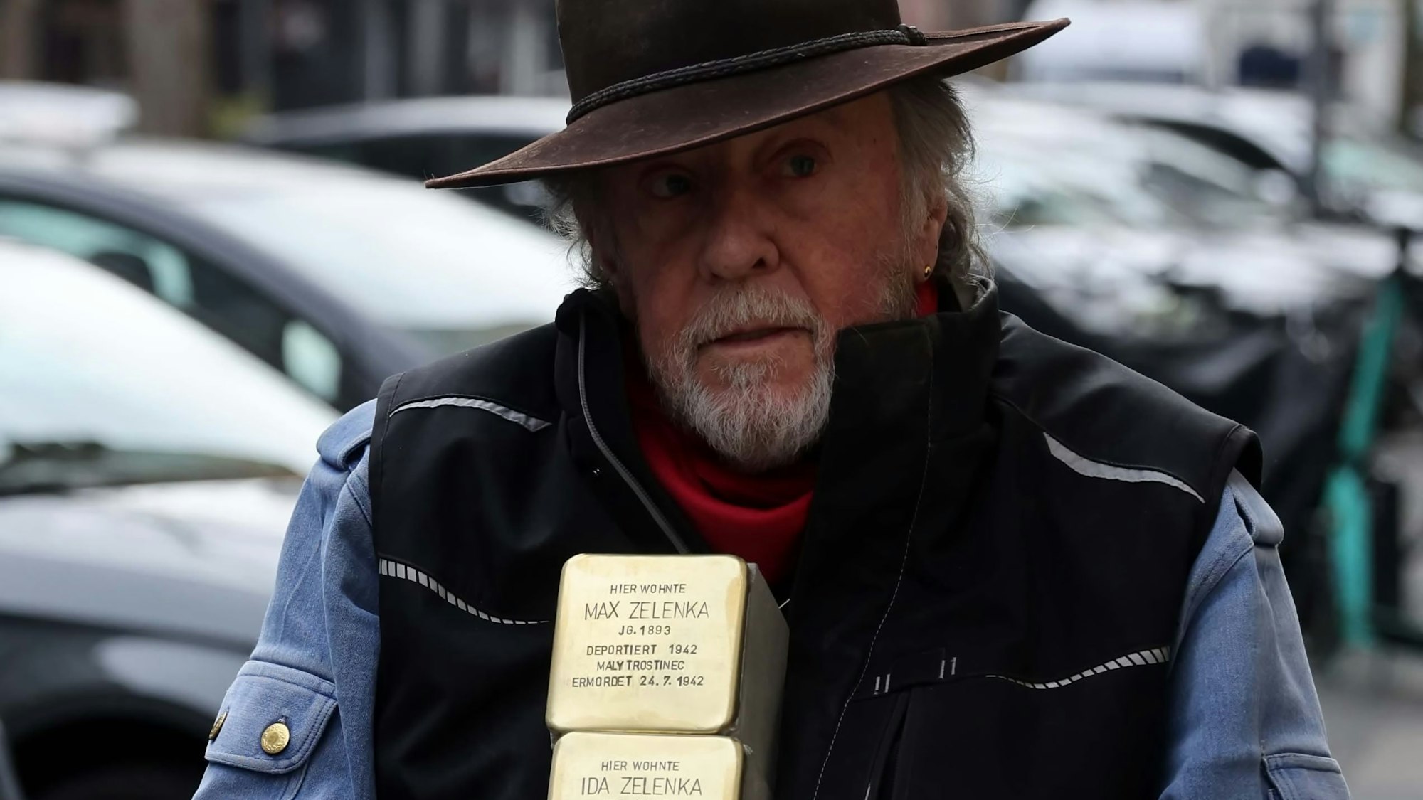 Gunter Demnig hält zwei Stolpersteine in den Händen.