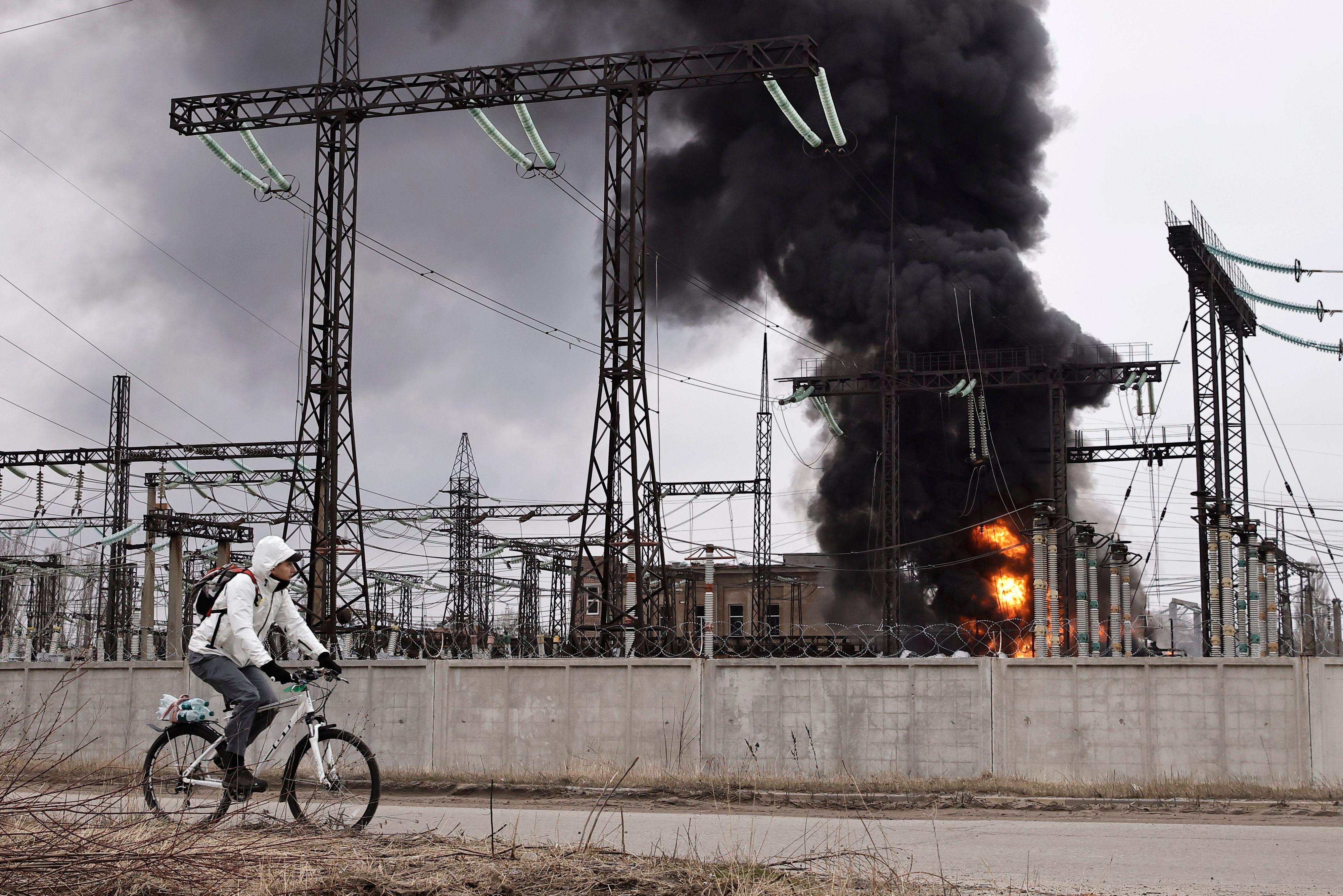ARCHIV - 22.03.2024, Ukraine, Charkiw: Ein Mann radelt nach einem russischen Angriff an einem Elektrizitätswerk vorbei.
