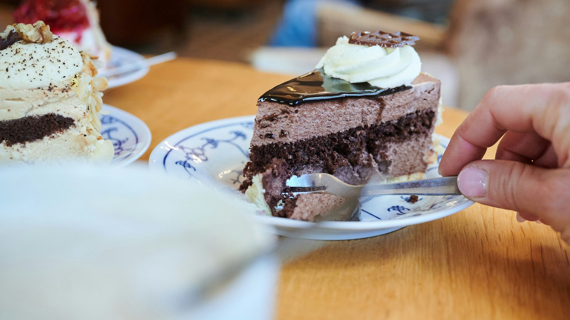 Eine Frau sticht mit der Kuchengabel in ein Stück Torte. Wer gerne einmal gepflegt Kaffeetrinken gehen möchte, kann sich mit diesem Wunsch an die Rundschau-Altenhilfe wenden.