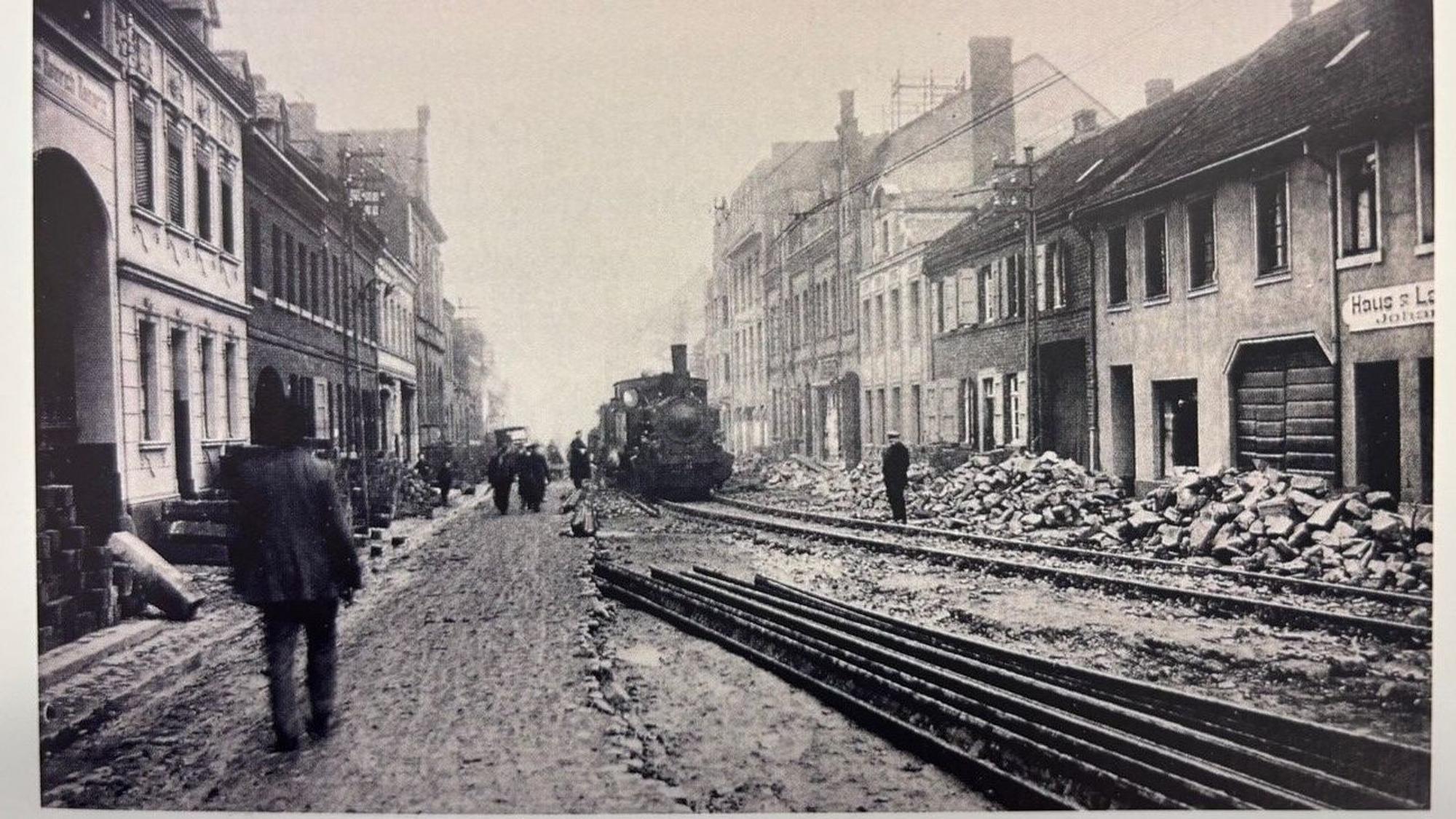 Auf dem Bild ist eine SW Aufnahme der Hauptstraße zwischen 1925 und 1928 zu sehen.