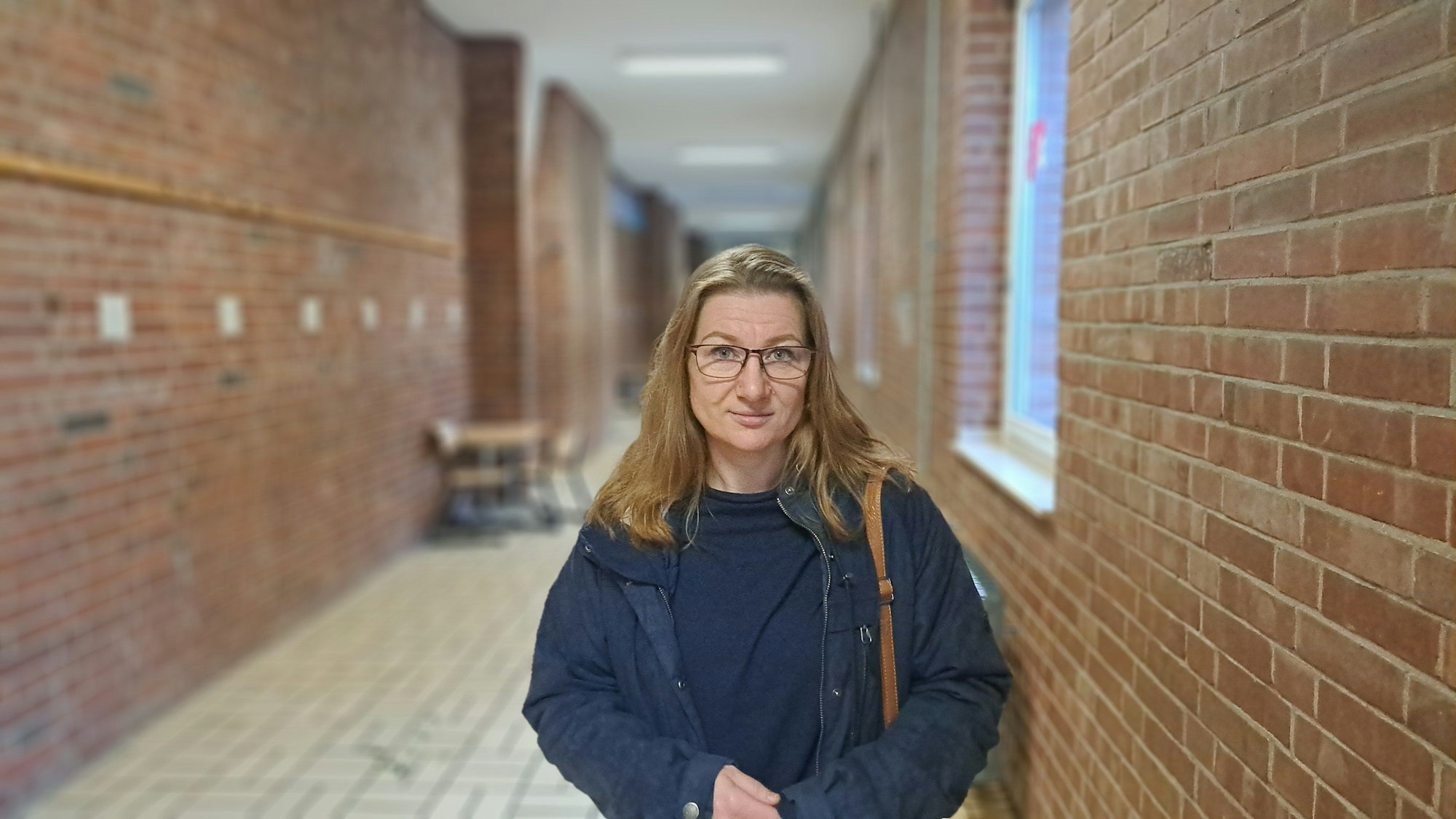 Eine Frau steht in einem Flur eines Schulgebäudes