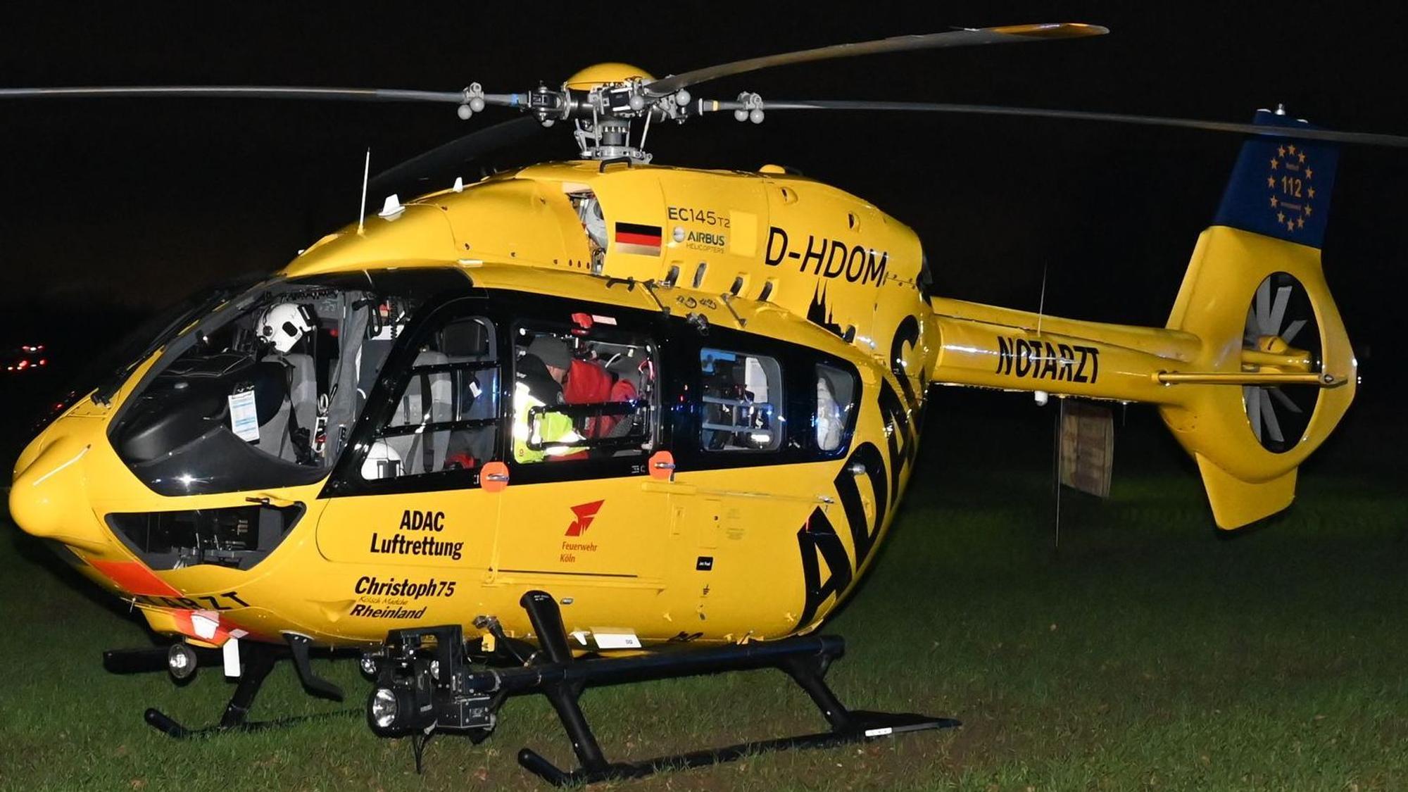 Das Bild zeigt einen Rettungshubschrauber neben einem Weg.