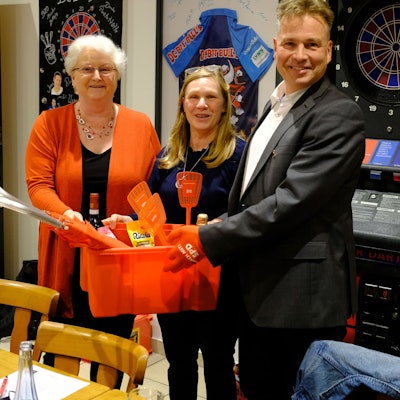 SPD-Ortsvereinsvorsitzende Ute Wagener (l.) überreicht Dr. Peter Schweikert-Wehner eine rote Plastikkiste. In der Mitte die Ehefrau des Kandidaten, Dr. Kirstin Wehner.