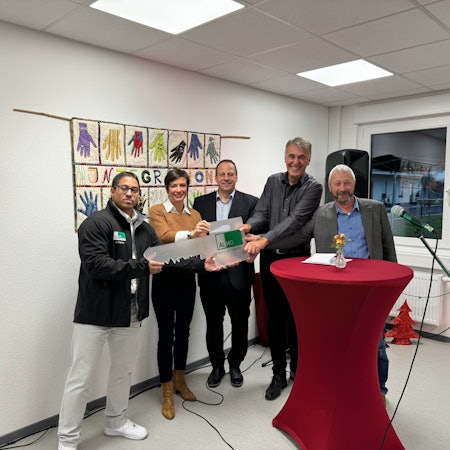 Das Foto zeigt eine Gruppe von Menschen mit einem symbolischen Schlüssel.