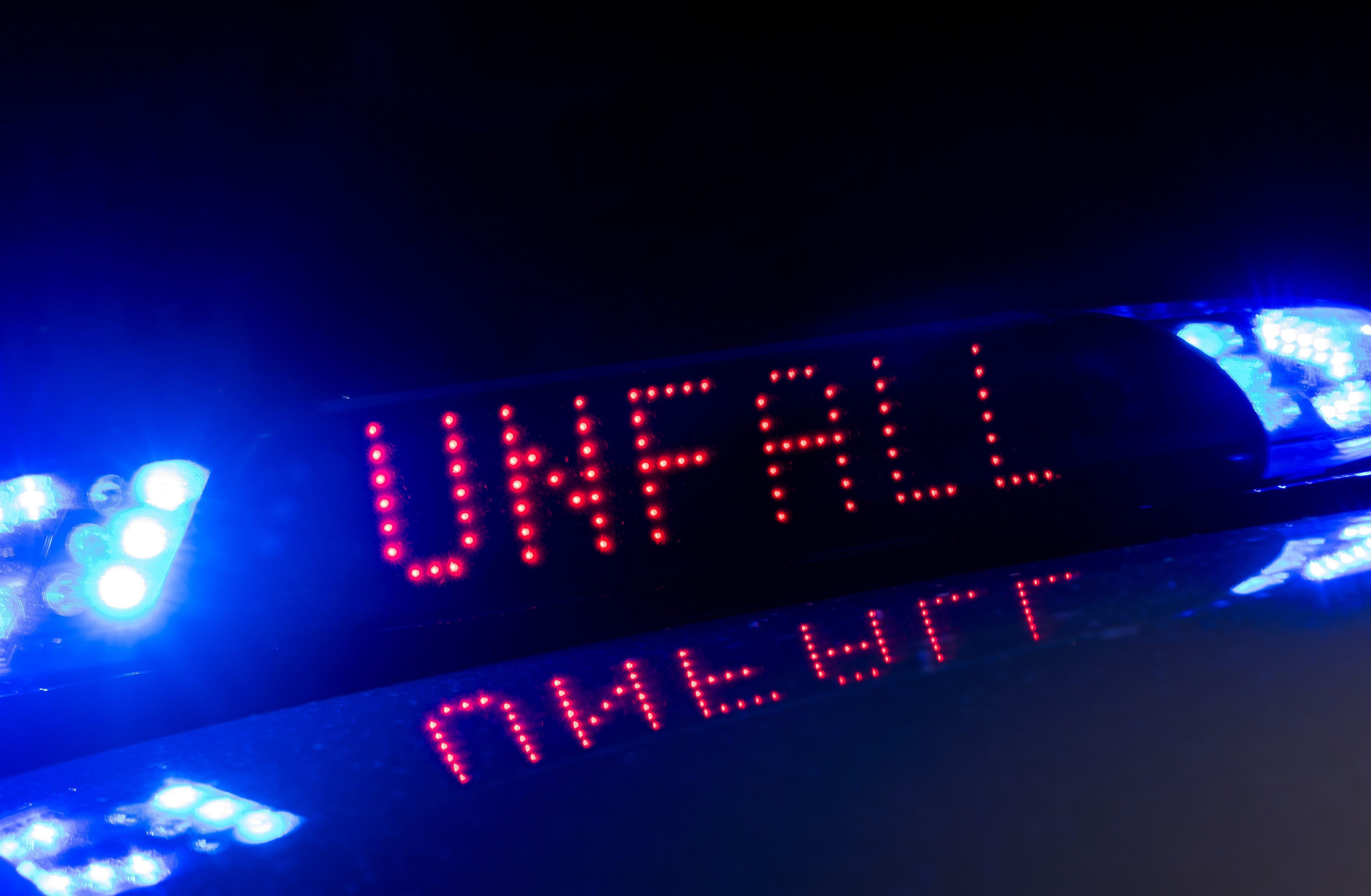 ARCHIV - 30.06.2018, Sachsen, Dresden: Das Blaulicht auf einem Fahrzeug der Polizei leuchtet in der Dunkelheit, während auf dem Display der Hinweis «Unfall» zu lesen ist.