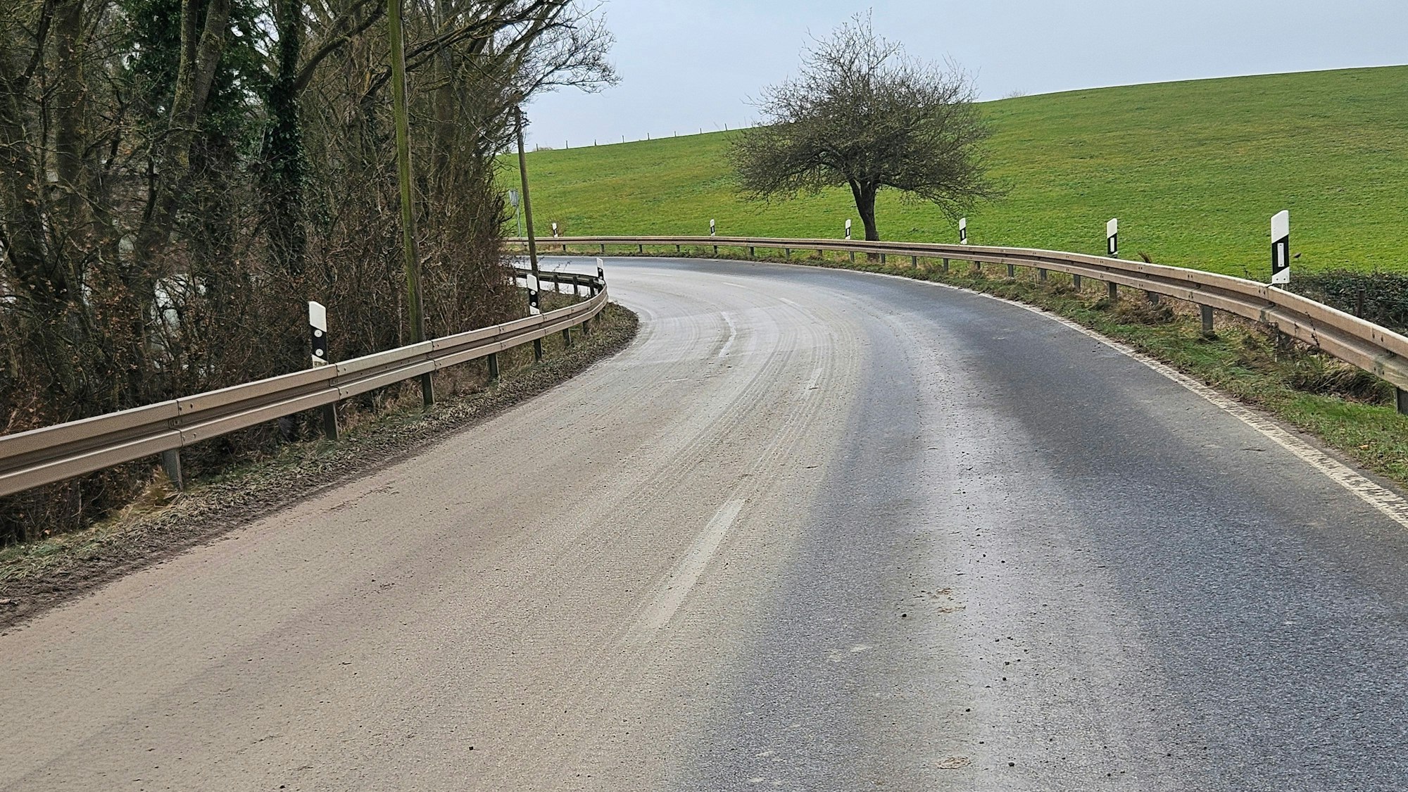 Das Foto zeigt eine Straße, von der eine Fahrbahn hellbraun vom Matsch ist.