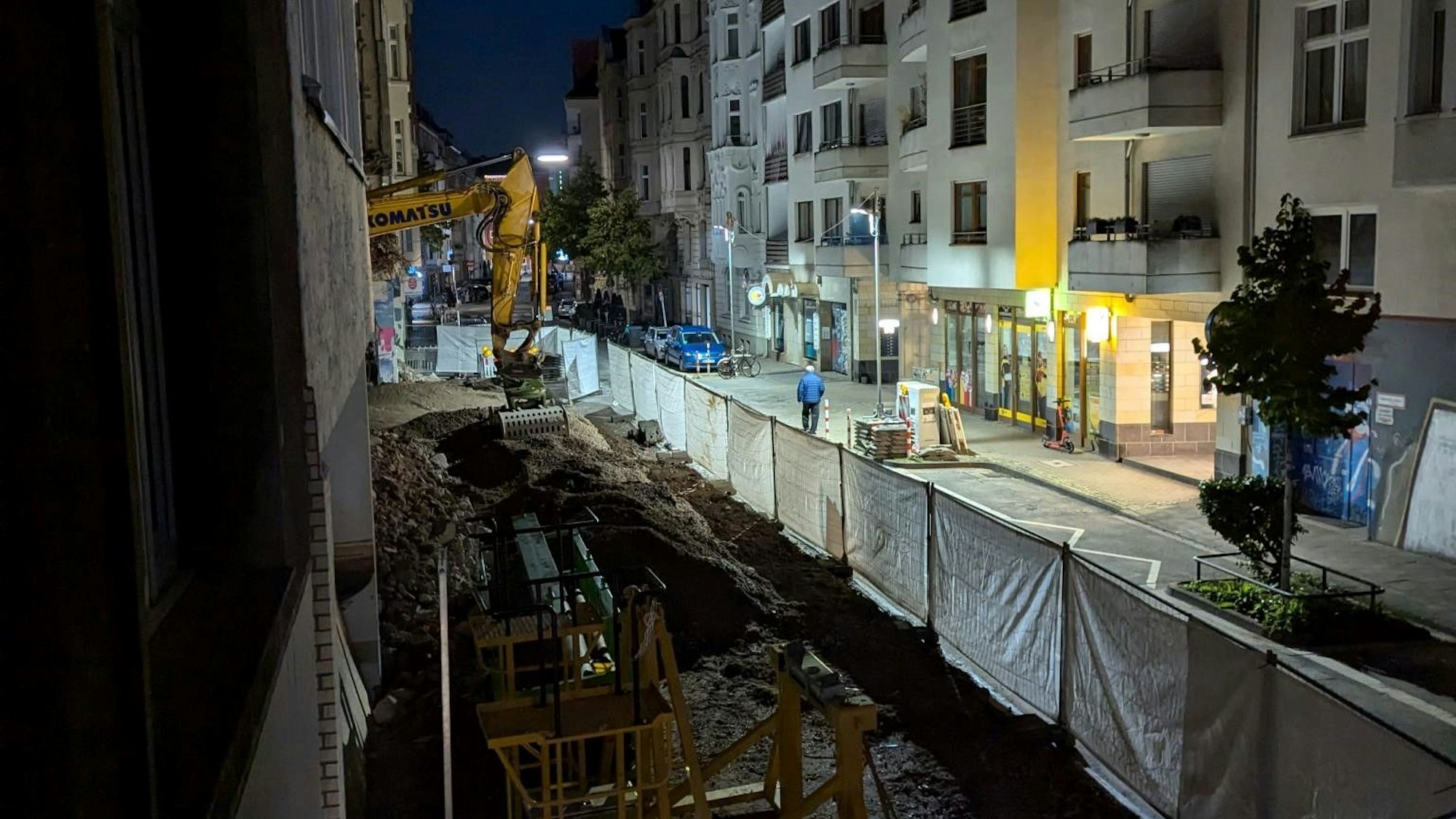Die Grundschul-Baustelle Antwerpener Straße am frühen Abend. Im Hintergrund sind zwei Mastleuchten zu sehen.