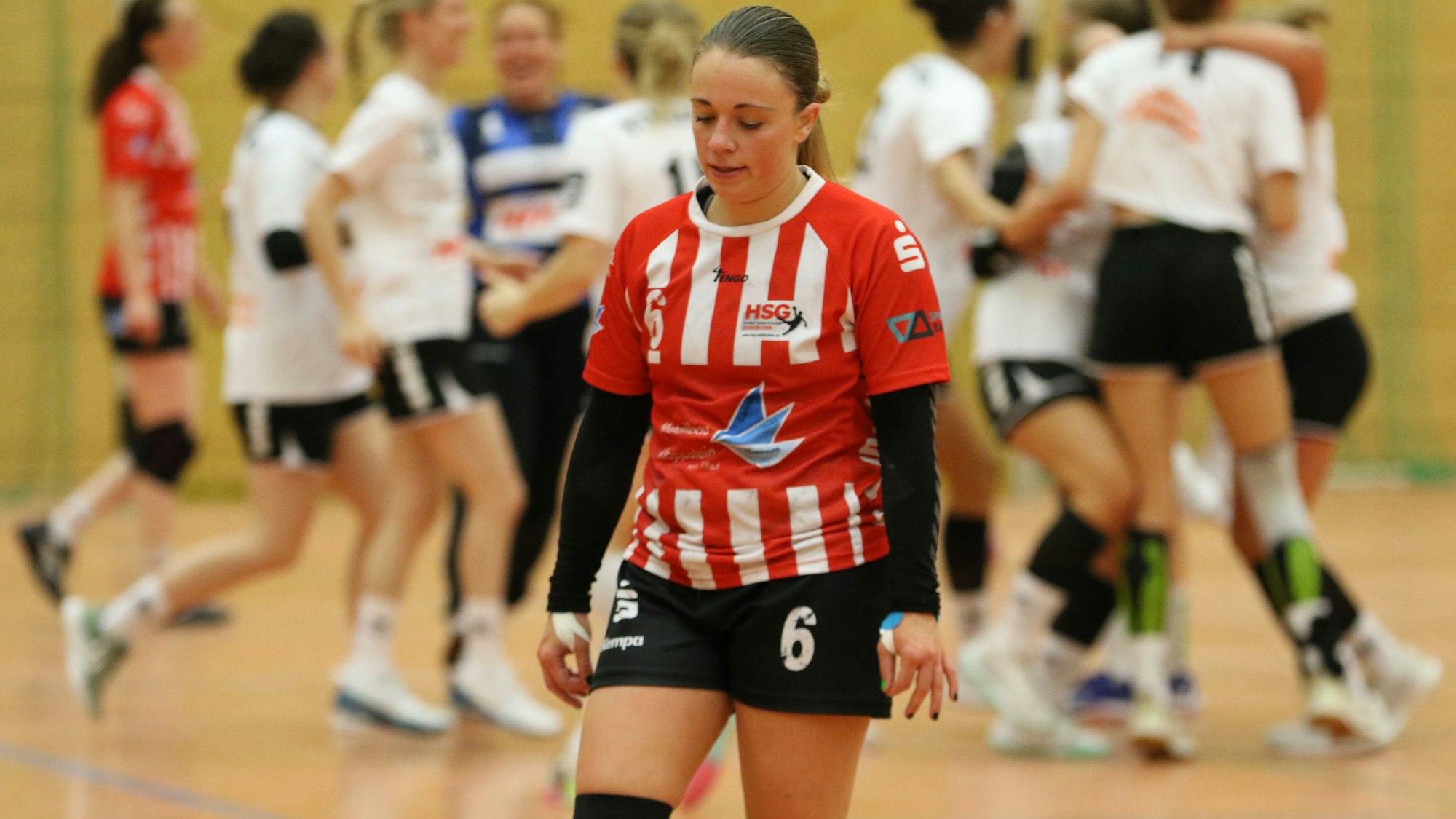 Das Bild zeigt Handballerin Svenja Bank, die enttäuscht von der Platte geht.
