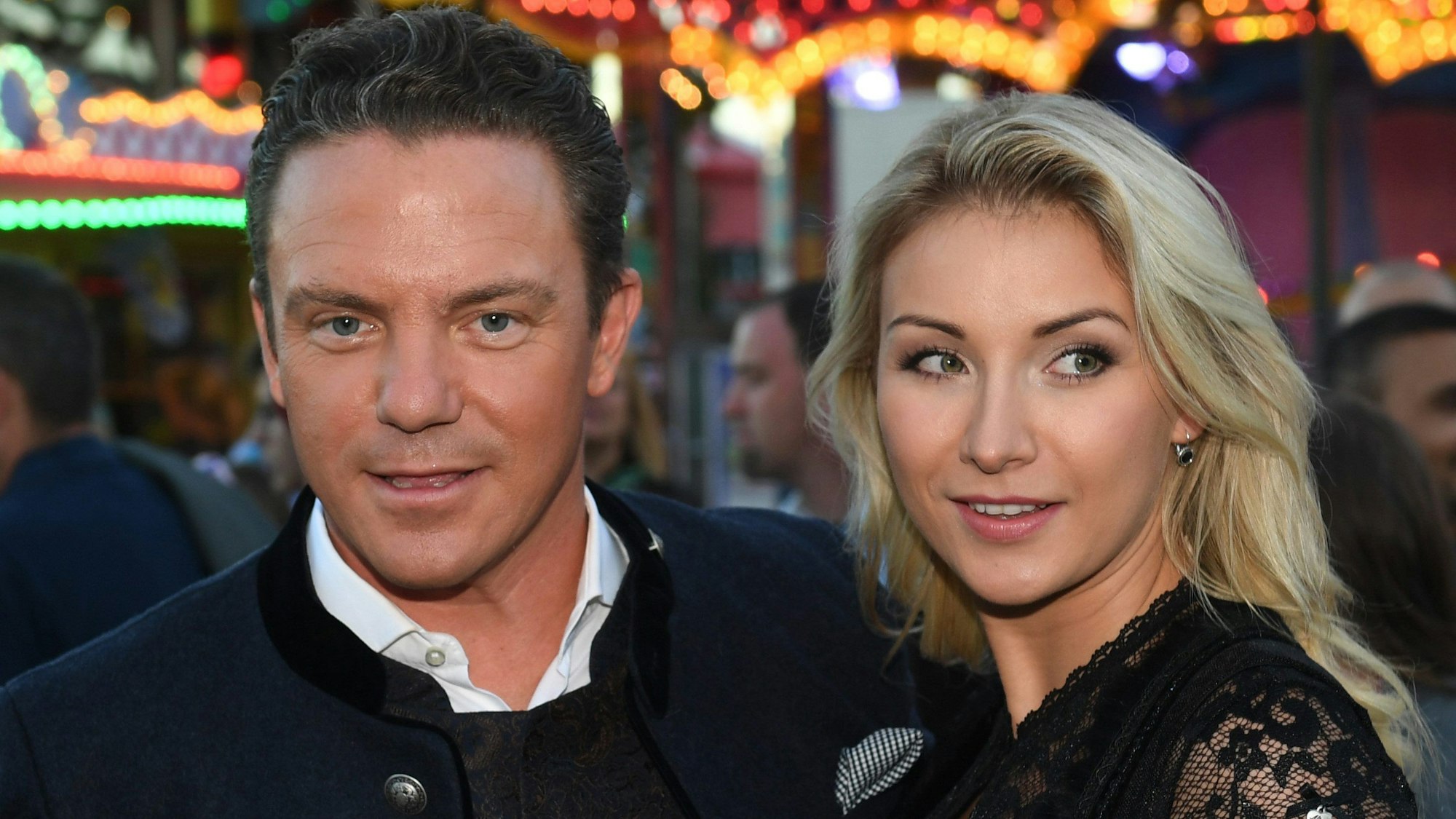 Stefan Mross und Anna-Carina Woitschack sind auf dem Oktoberfest vor eine Fahrgeschäft zu sehen.