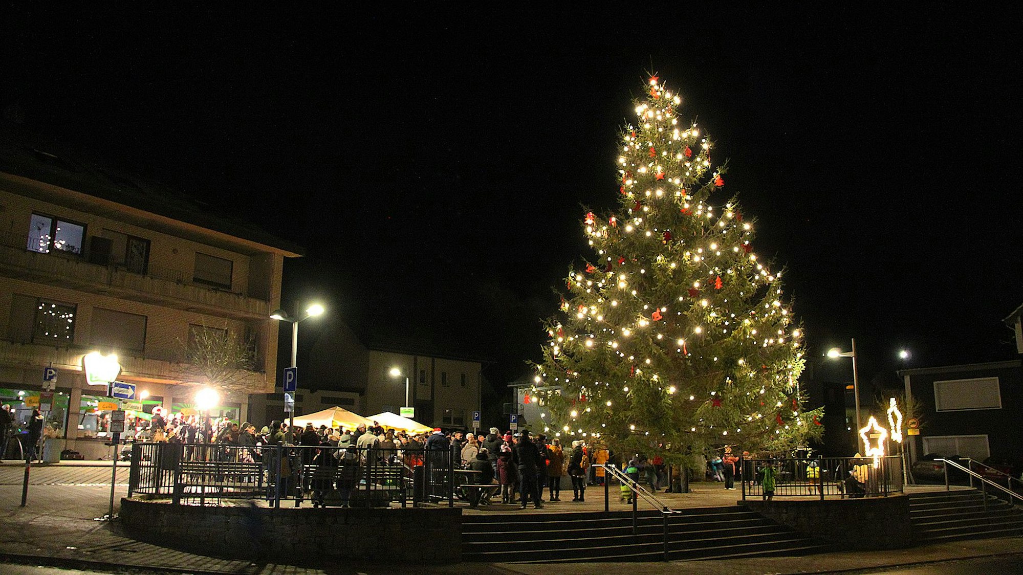 Das Bild zeigt den leuchtenden Weihnachtsbaum in Schmidtheim am Abend.