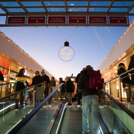 Menschen fahren auf einer Rolltreppe.