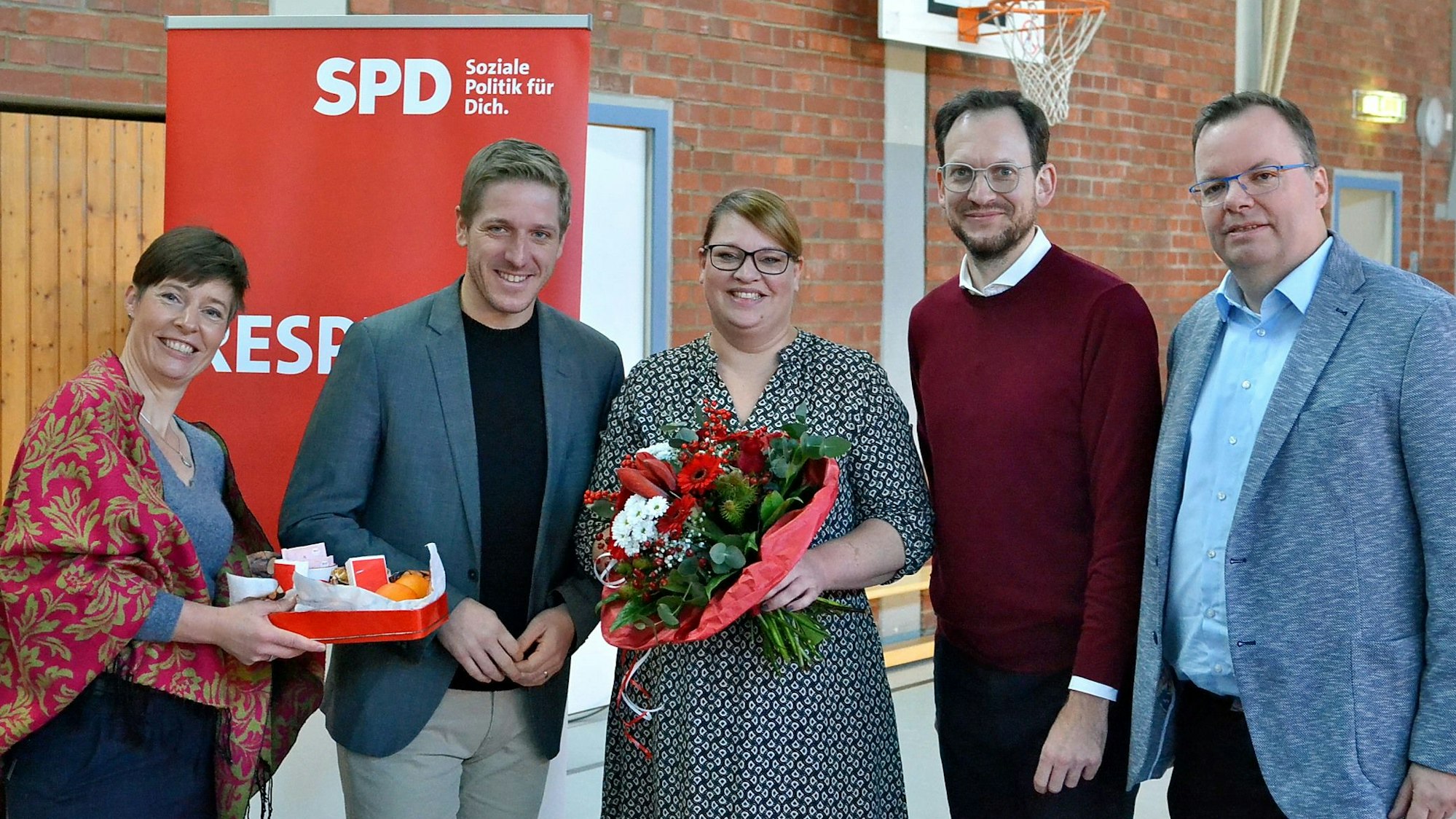 Annegret Lewak, Markus Rahmers, Andrea Kanonenberg, Thilo Waasem und Helge Herrwegen (v.l.n.r.) haben sich vor einem SPD-Roll-up zum Gruppenbild aufgestellt. Kanonenberg hält einen großen Blumenstrauß in Händen.