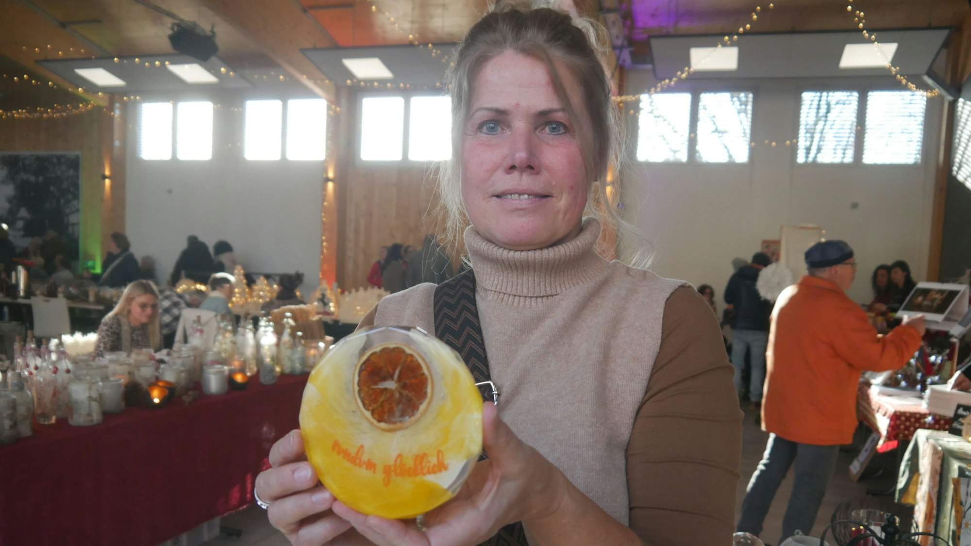 Eine Frau hält eine gelbe Scheibe in der Hand.