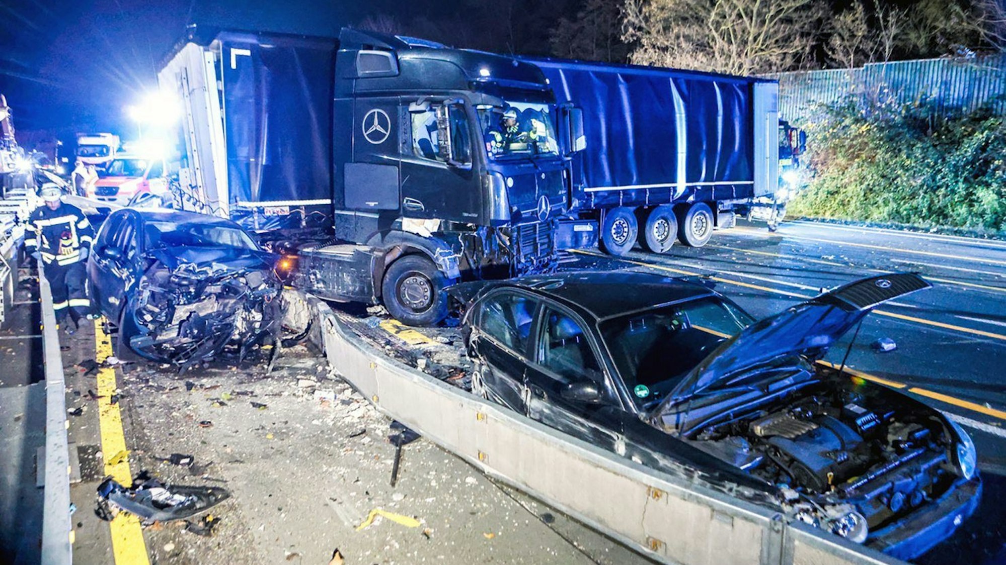 30.11.2024, Nordrhein-Westfalen, Hagen: Ein Lastwagen steht auf der Autobahn 1 bei Hagen an der Unfallstelle neben beschädigten Autos. Nach einer Chaosfahrt über mehrere Autobahnen hat die Polizei in Nordrhein-Westfalen einen auffälligen Lkw-Fahrer aus dem Verkehr gezogen. Es habe mehrere Unfälle und Sachschäden gegeben, wie die Polizei mitteilte. Foto: Alex Talash/dpa +++ dpa-Bildfunk +++