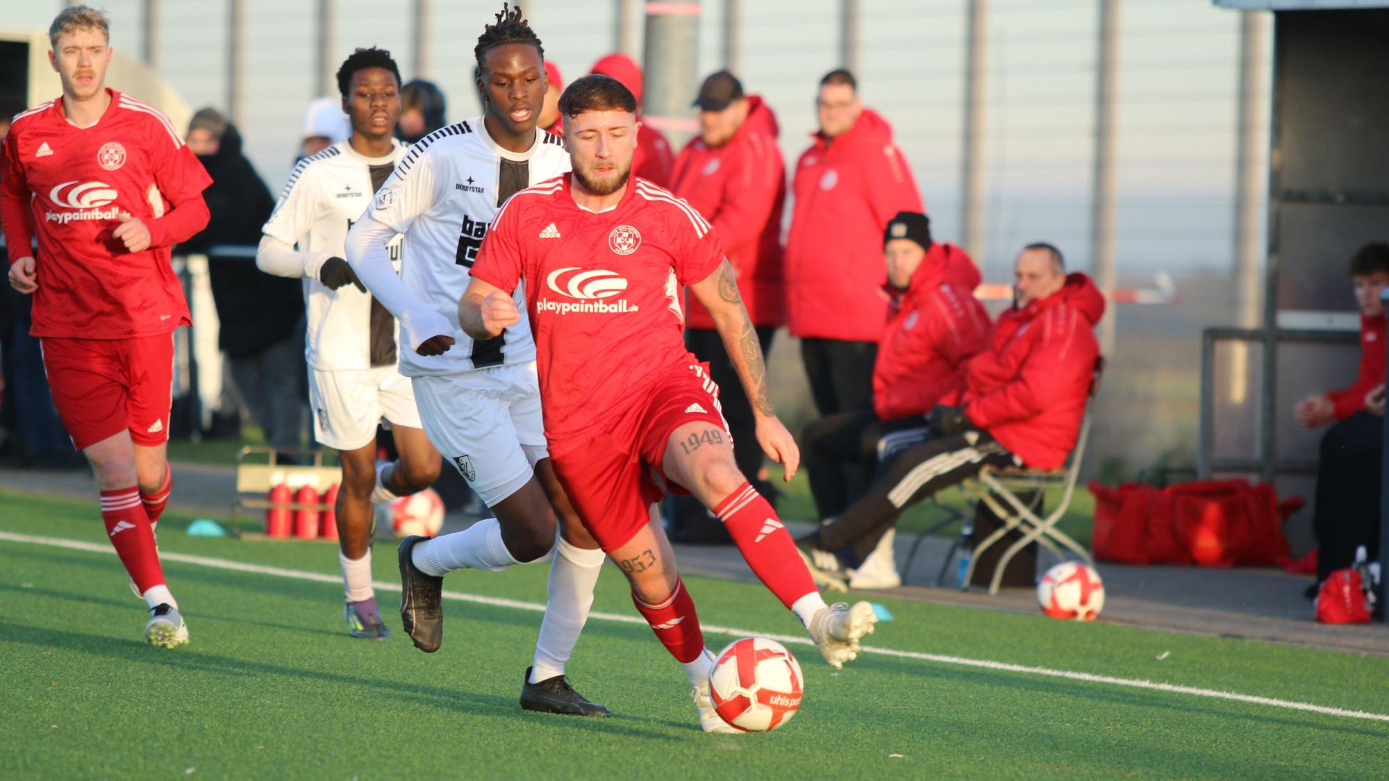 Nico Berekoven führt den Ball, ein Gegenspieler verfolgt ihn.