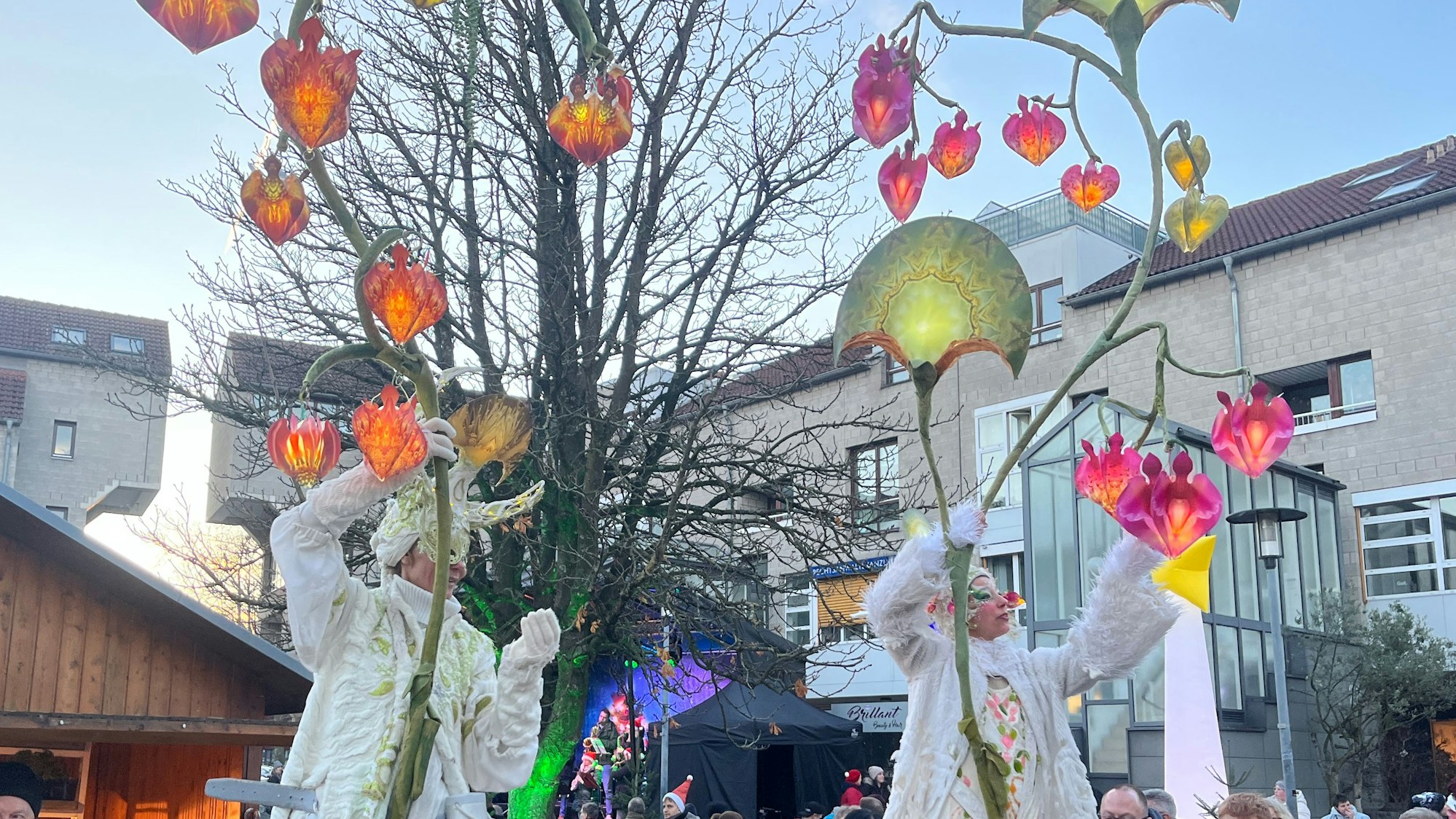 Phantasiegestalten und leuchtende Elemente an einer Metallkonstruktion.