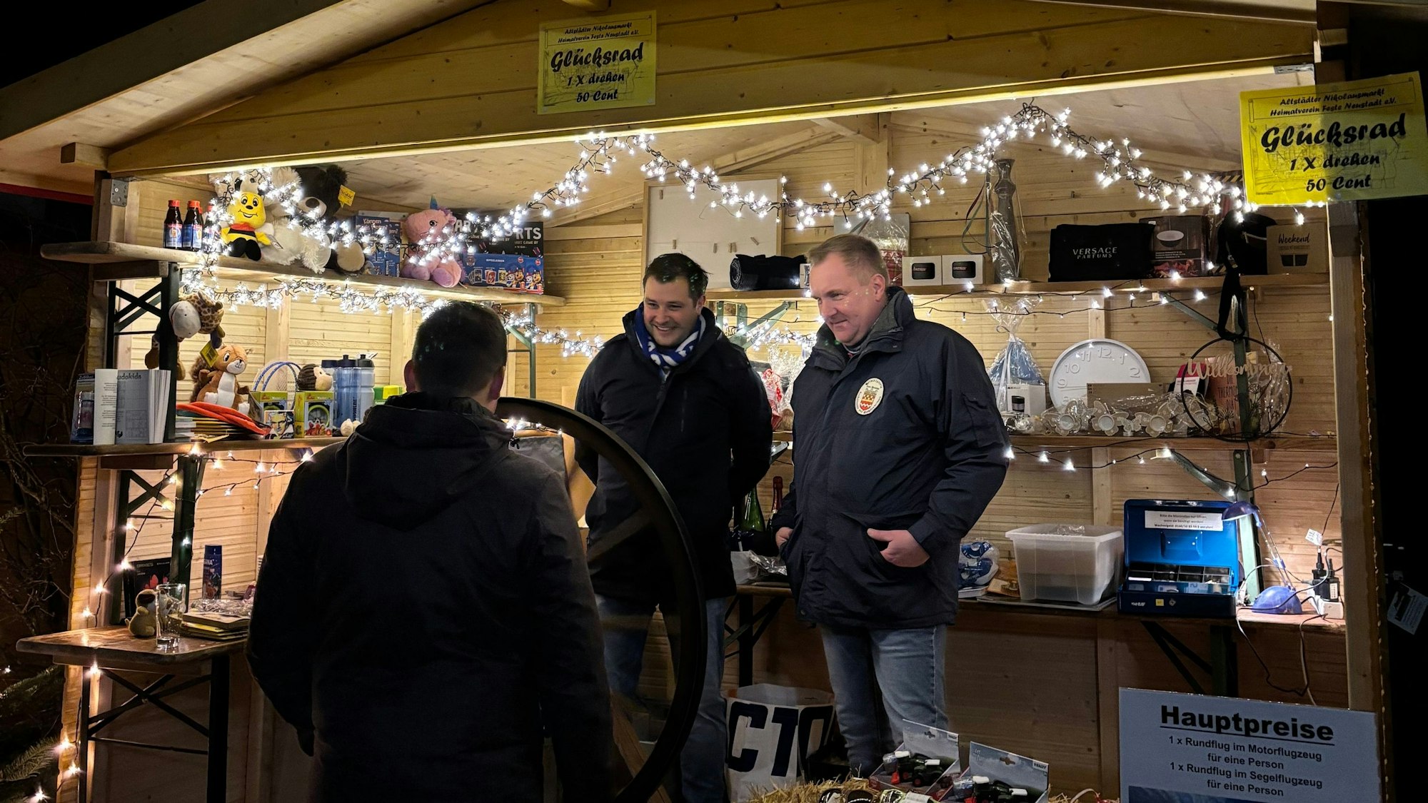 Drei Männer in einer hölzernen Bude.