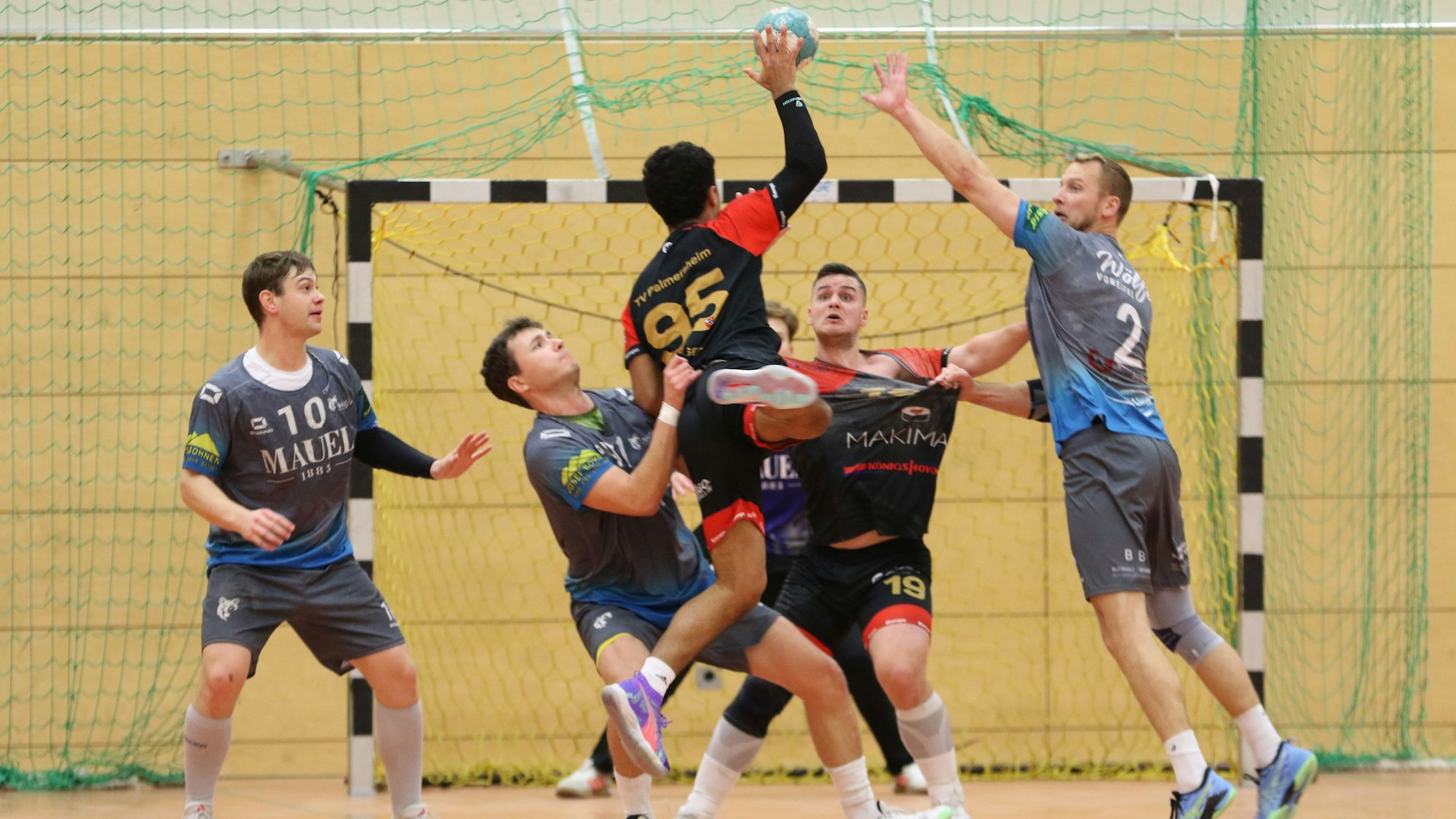 Zwei Abwehrspieler wollen Simsek am Wurf hindern, einer von ihnen hat gleichzeitig Kreisläufer Mayer am Trikot gepackt.